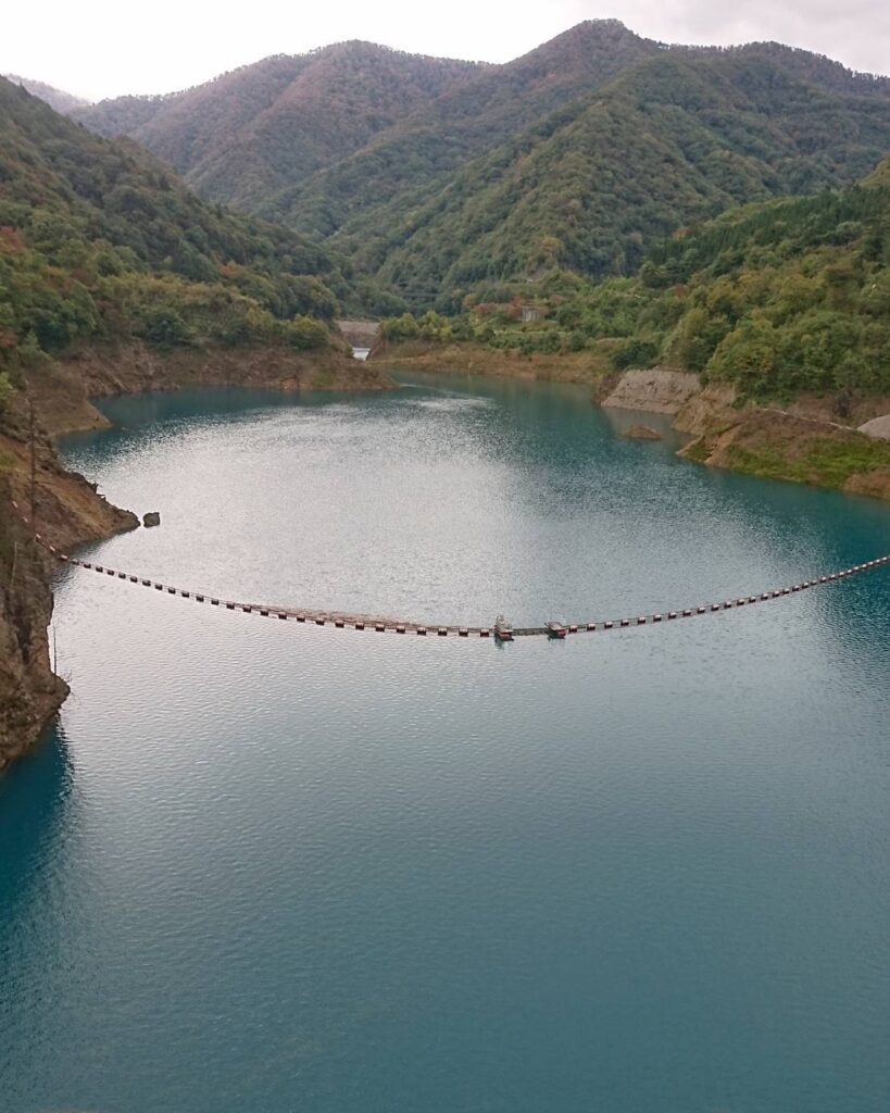 青緑色の奥四万湖と山