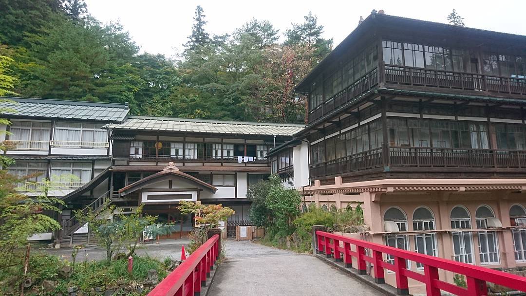 赤い橋の向こうに建つ積善館と元禄の湯