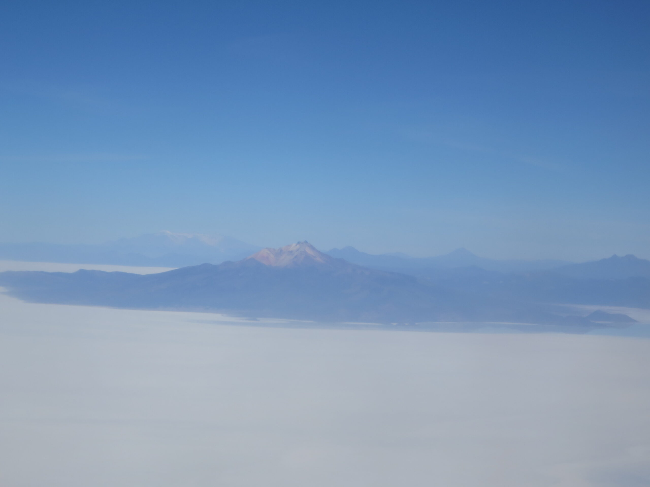 飛行機の窓から見下ろしたウユニ塩湖と山