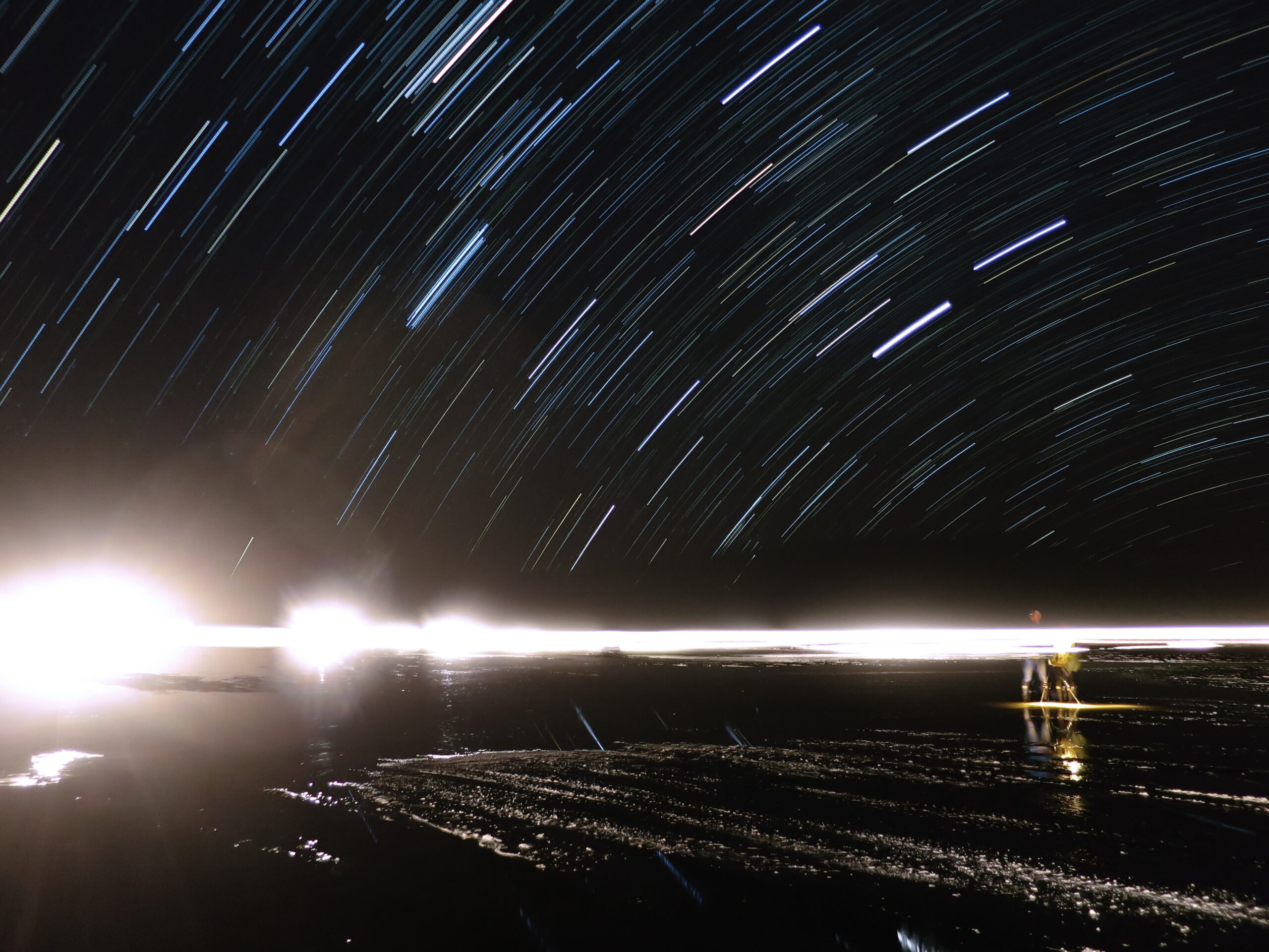 夜のウユニ塩湖の上に描かれた星の軌跡