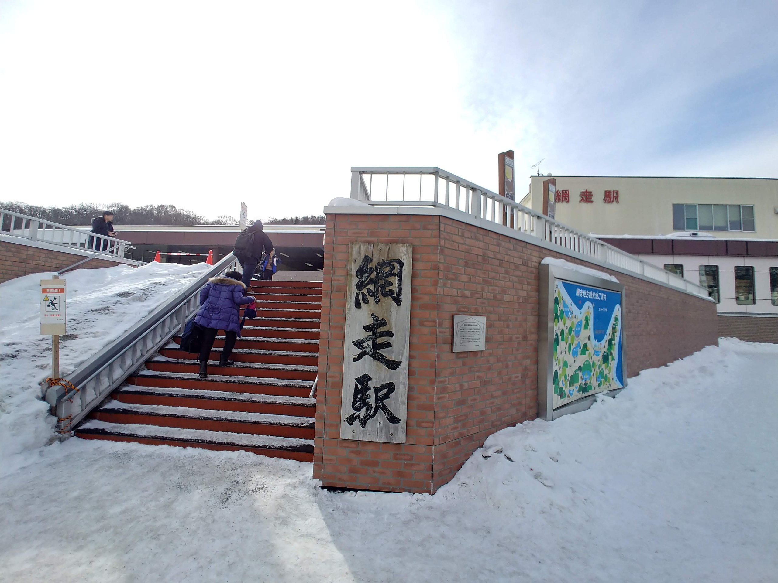 雪の中の「網走駅」の看板と階段