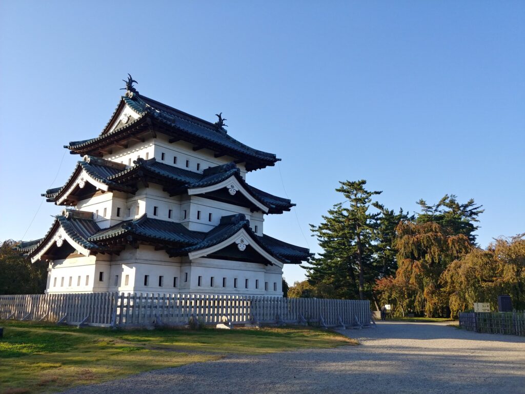 青空の下に立つ弘前城の三層の天守