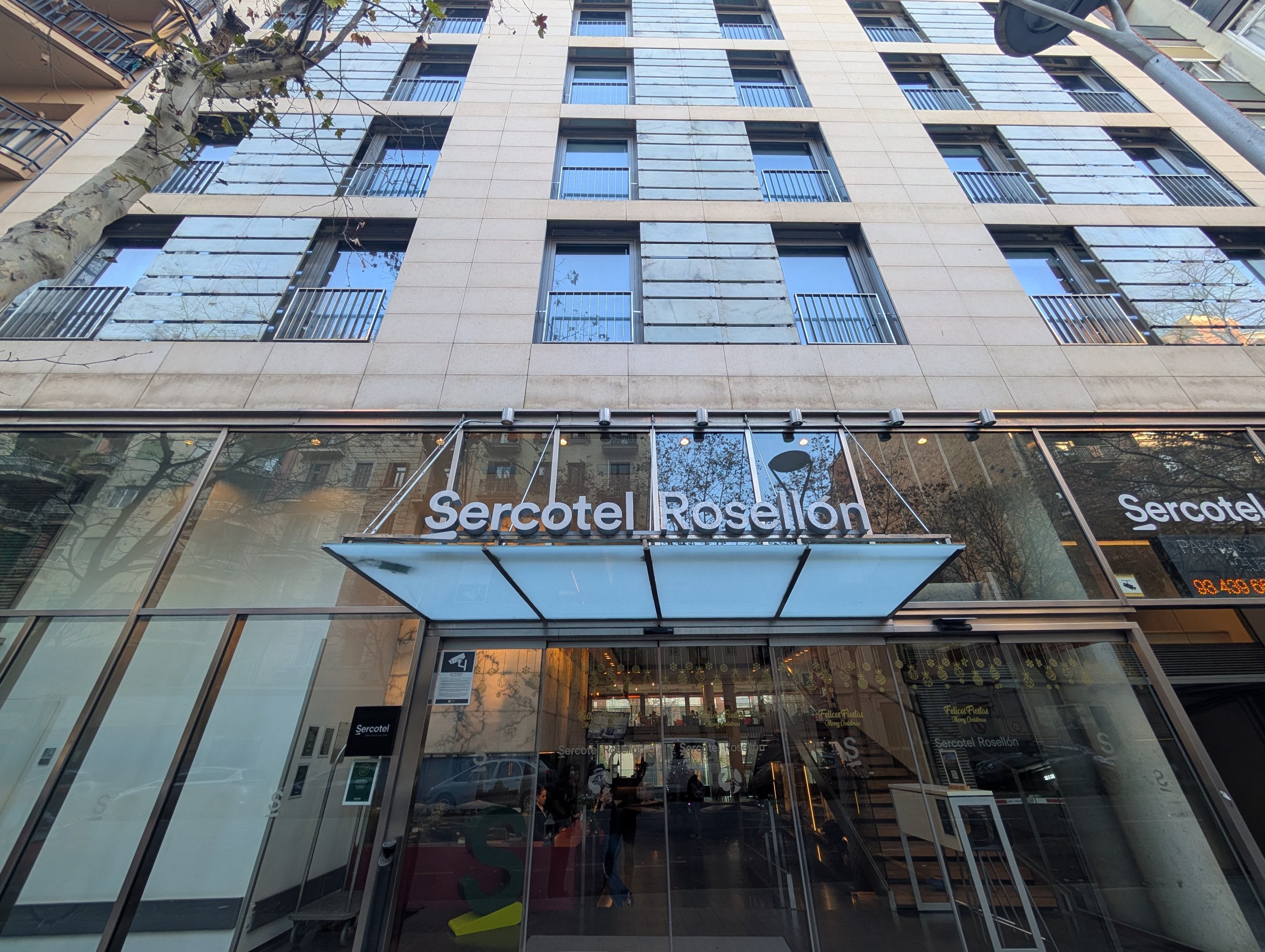 ガラス張りの入口の上に「Sercotel Rosellón」の看板があるホテルの外観
