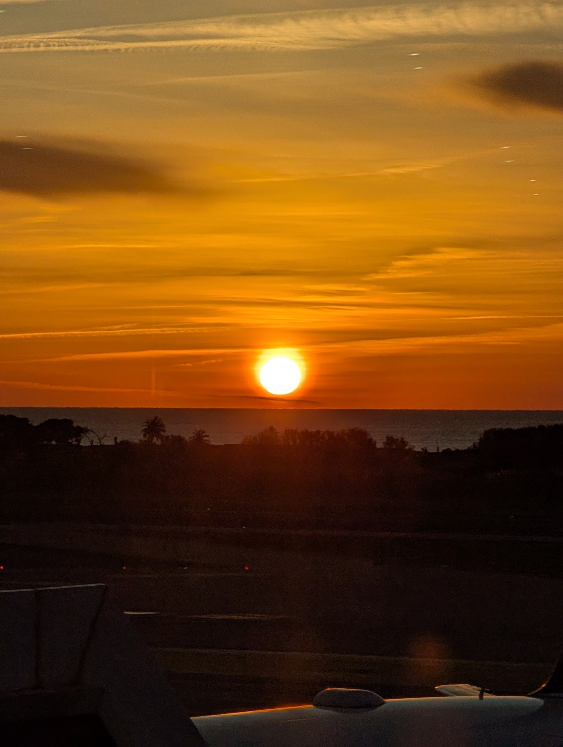 バルセロナの空港から見た朝日。オレンジ色の空と海に昇る太陽