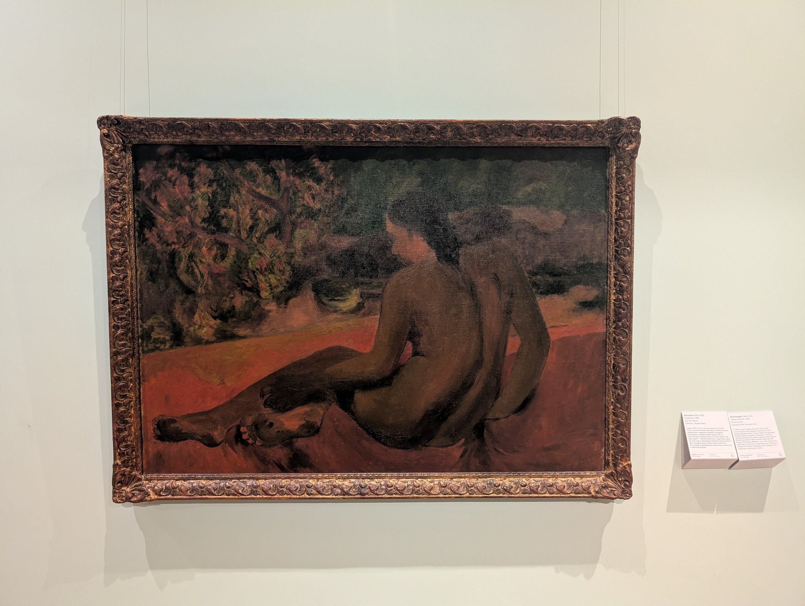 ゴーギャン「タヒチの女」(1898年)。赤い背景に横たわる女性の後ろ姿