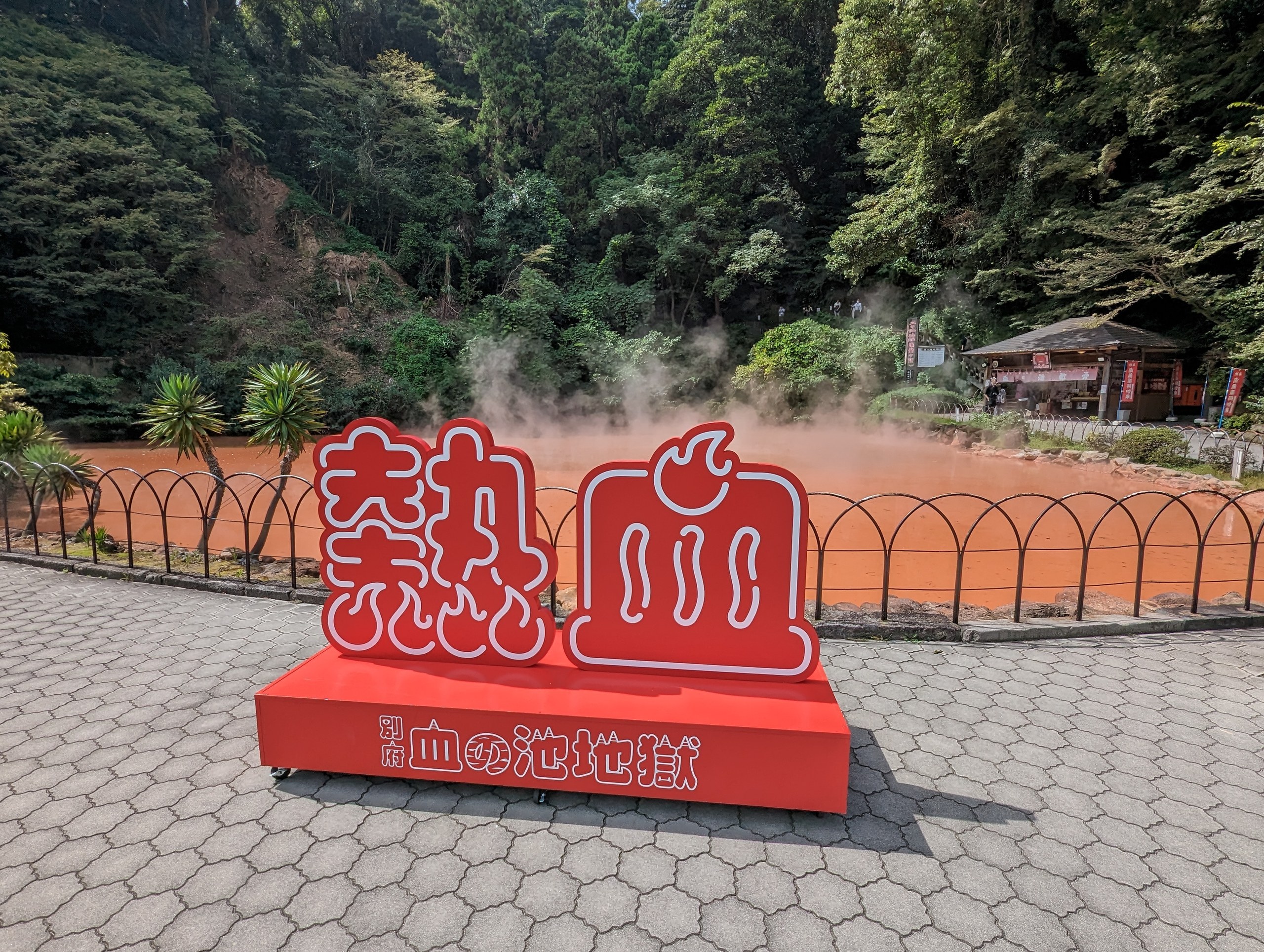 「熱血」の文字の赤いオブジェと、奥の赤い池