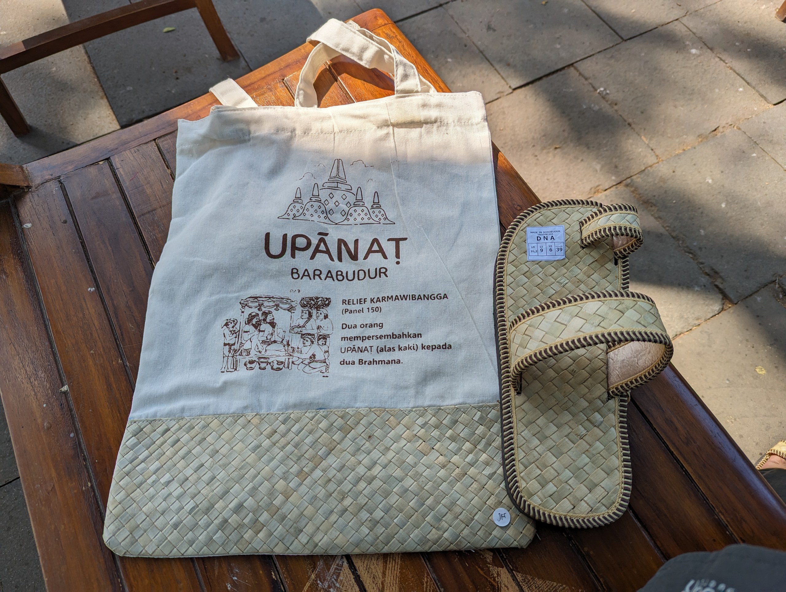 「UPANAT BARABUDUR」と書かれた布の袋と、わらで編んだサンダル