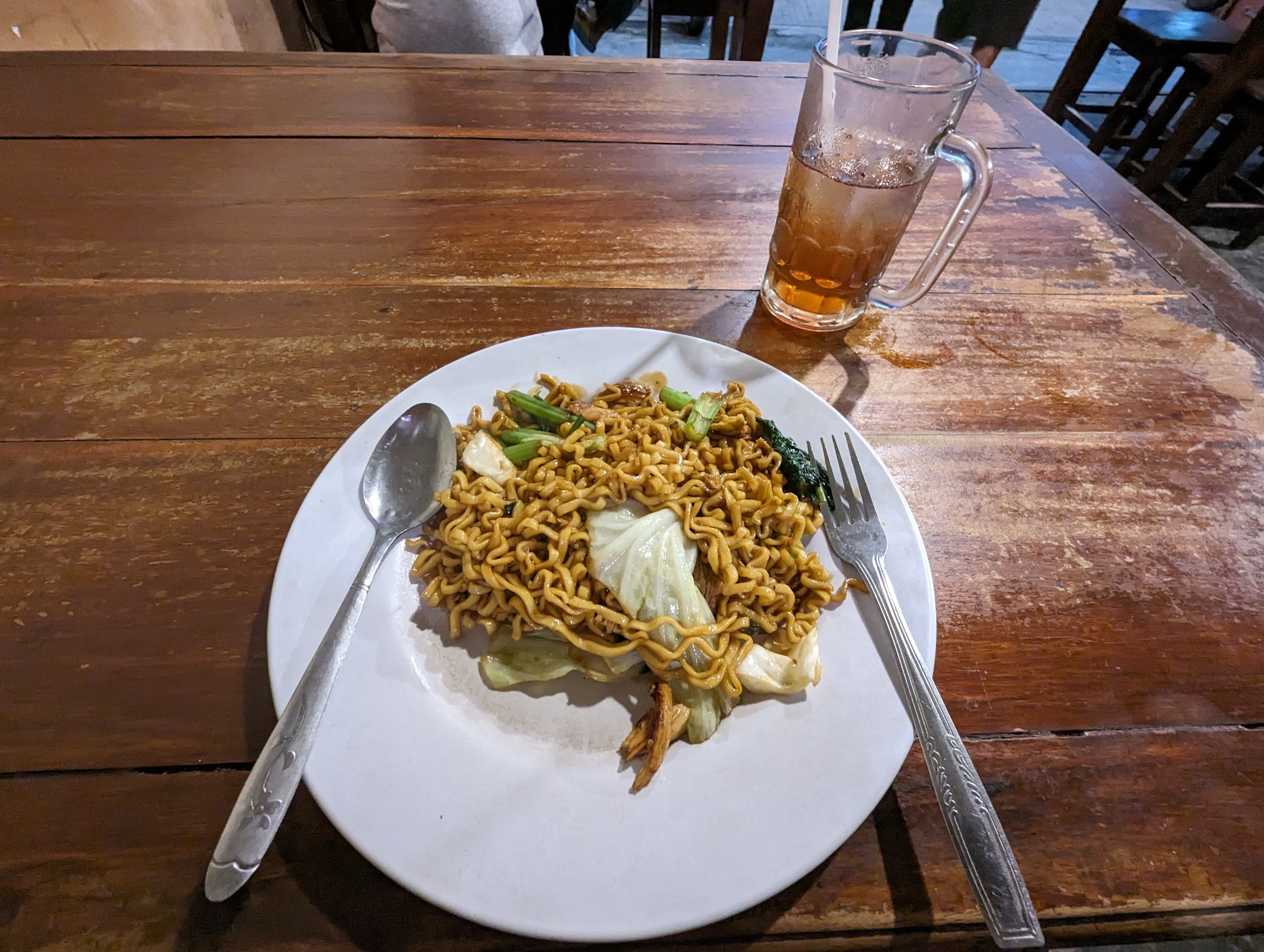 木のテーブルの上の、皿に盛られた焼きそば