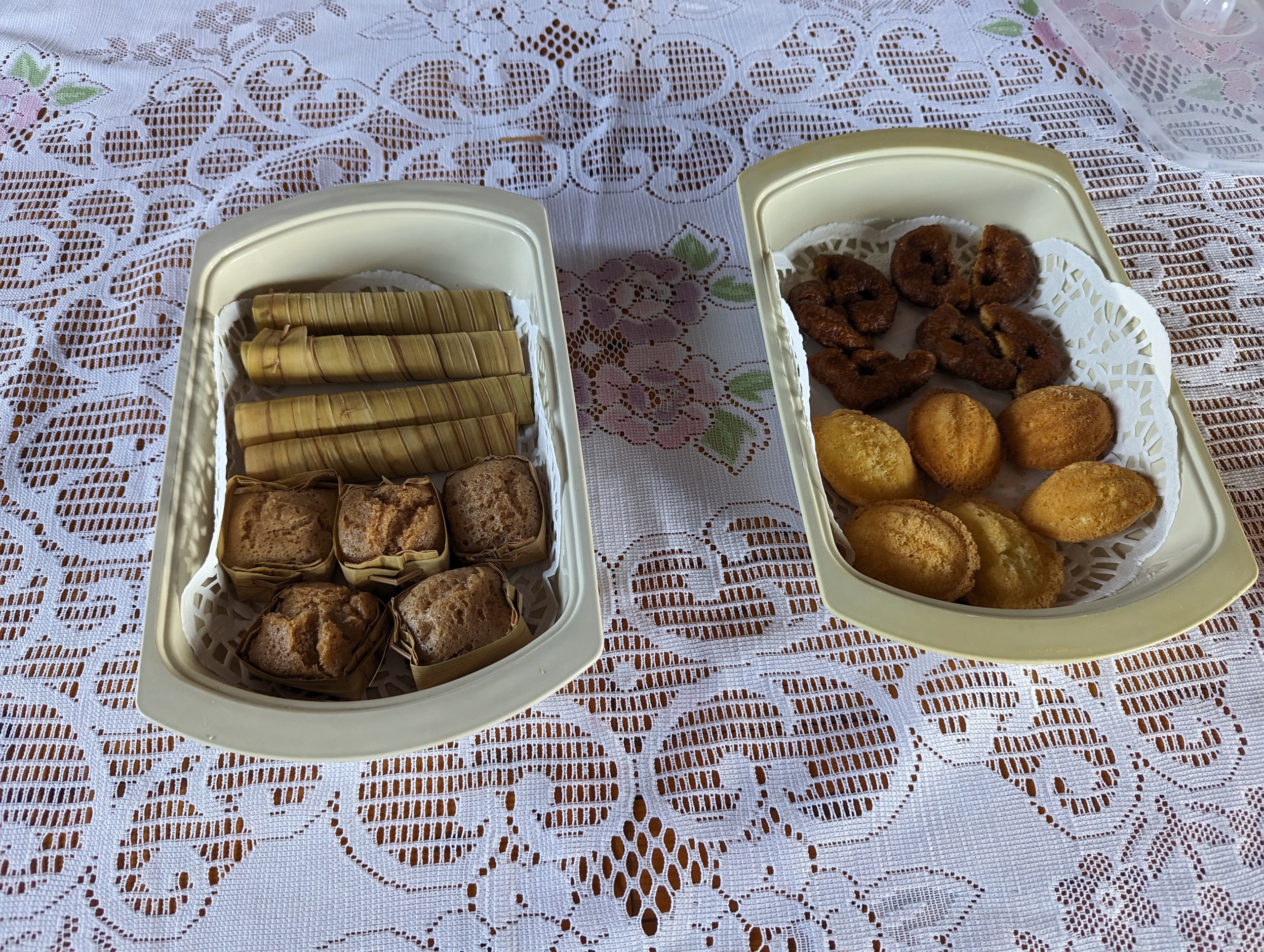 レースのテーブルクロスの上に並ぶ、巻いたお菓子と焼き菓子