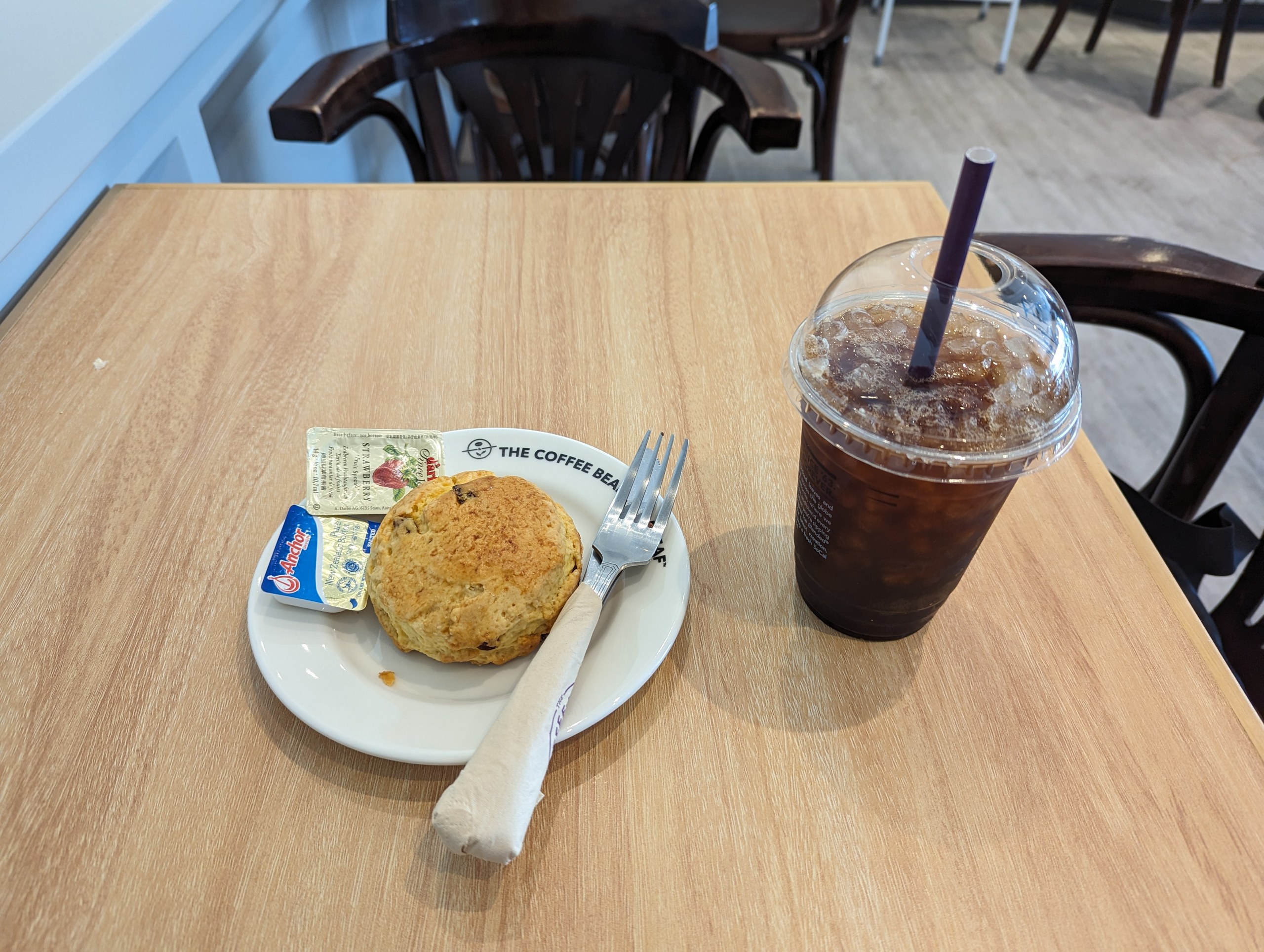 カフェのテーブルに置かれた、スコーンとアイスコーヒー