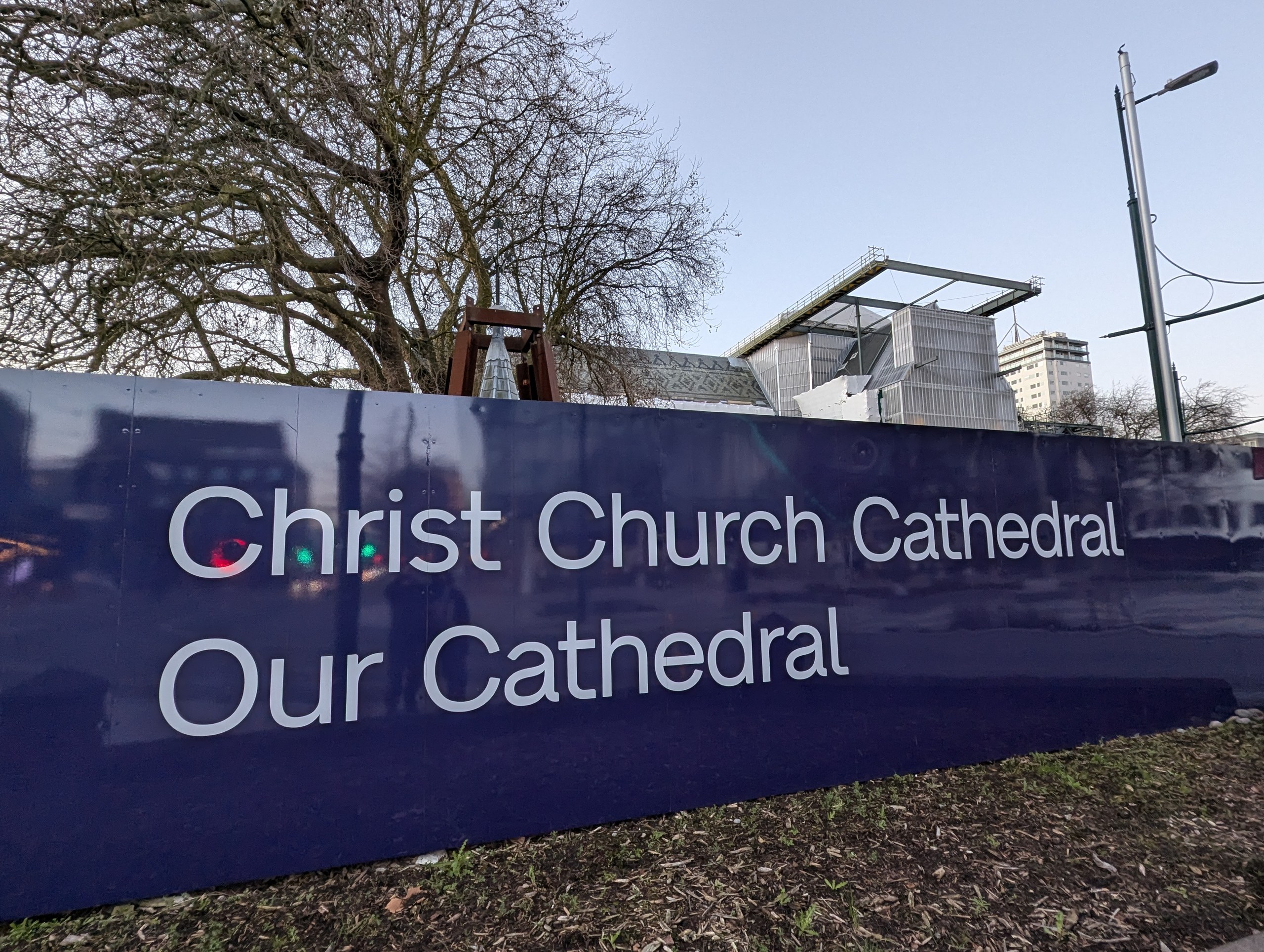 「Christ Church Cathedral Our Cathedral」と書かれた紺色の囲いと、奥の工事中の建物