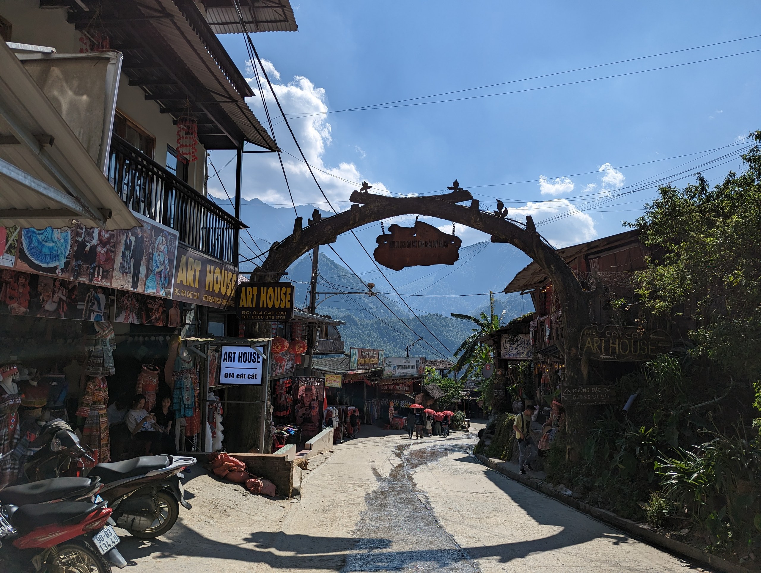 木のアーチの門の先に続く、村への坂道