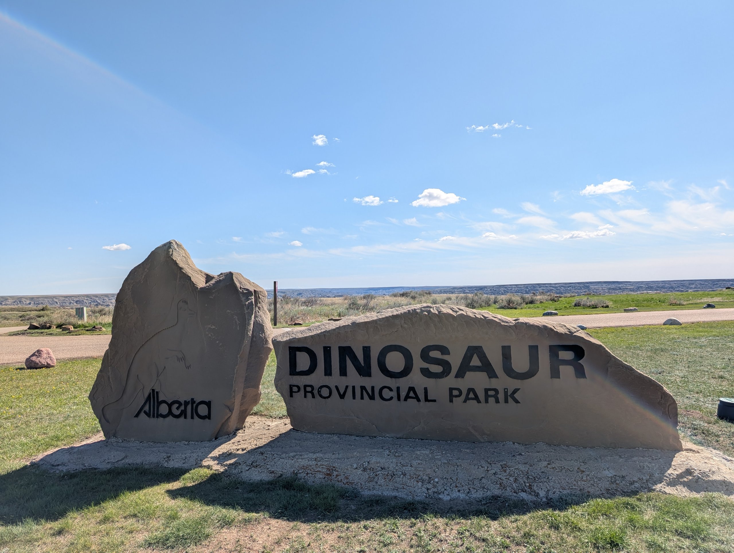 草原に置かれた「DINOSAUR PROVINCIAL PARK」の文字が入った大きな石