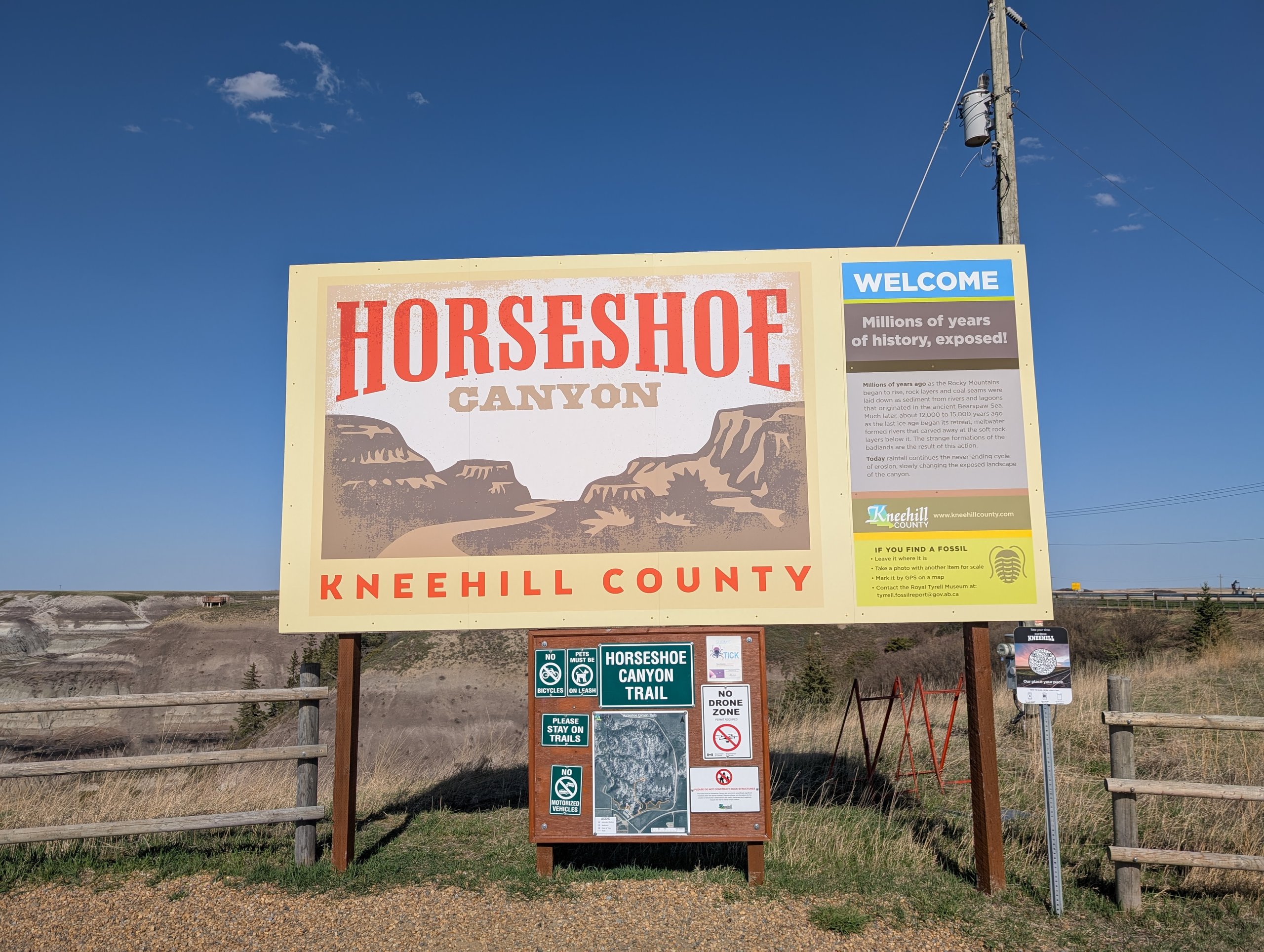 「HORSESHOE CANYON」の看板と、その後ろに広がる谷