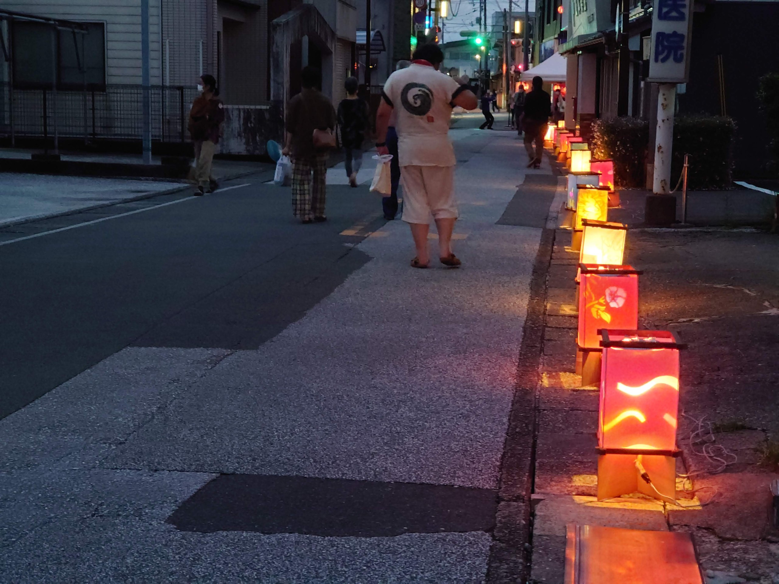 ろうそくの灯籠が並ぶ、夕暮れの商店街の道