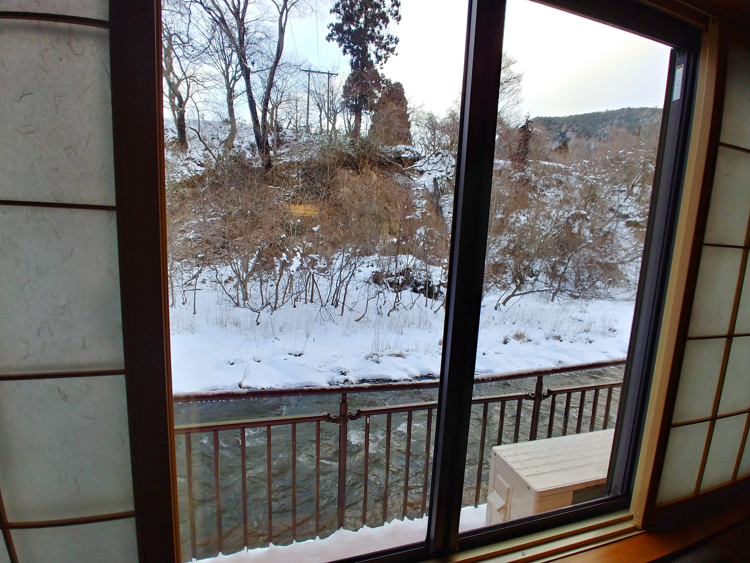部屋の窓から見た雪の川