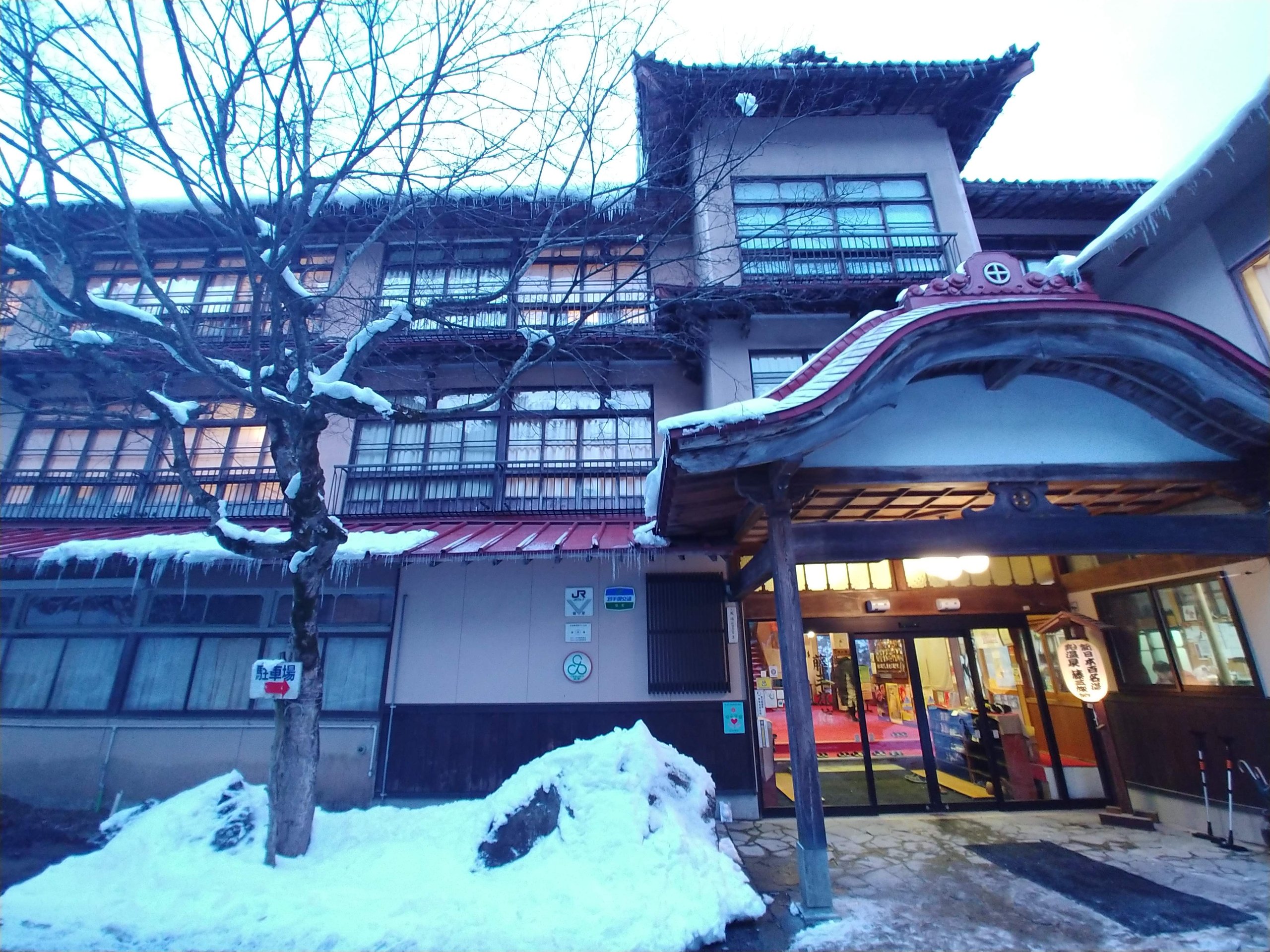 雪の残る藤三旅館の外観