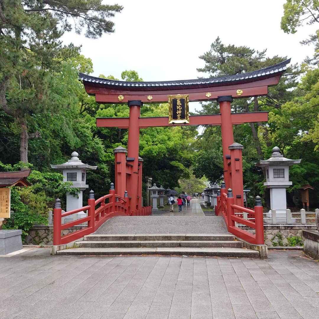 朱色の鳥居と太鼓橋のある、神社の参道