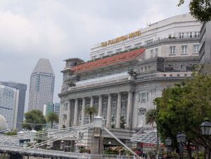 川沿いから見た、白い柱が並ぶザ フラートン ホテルの外観