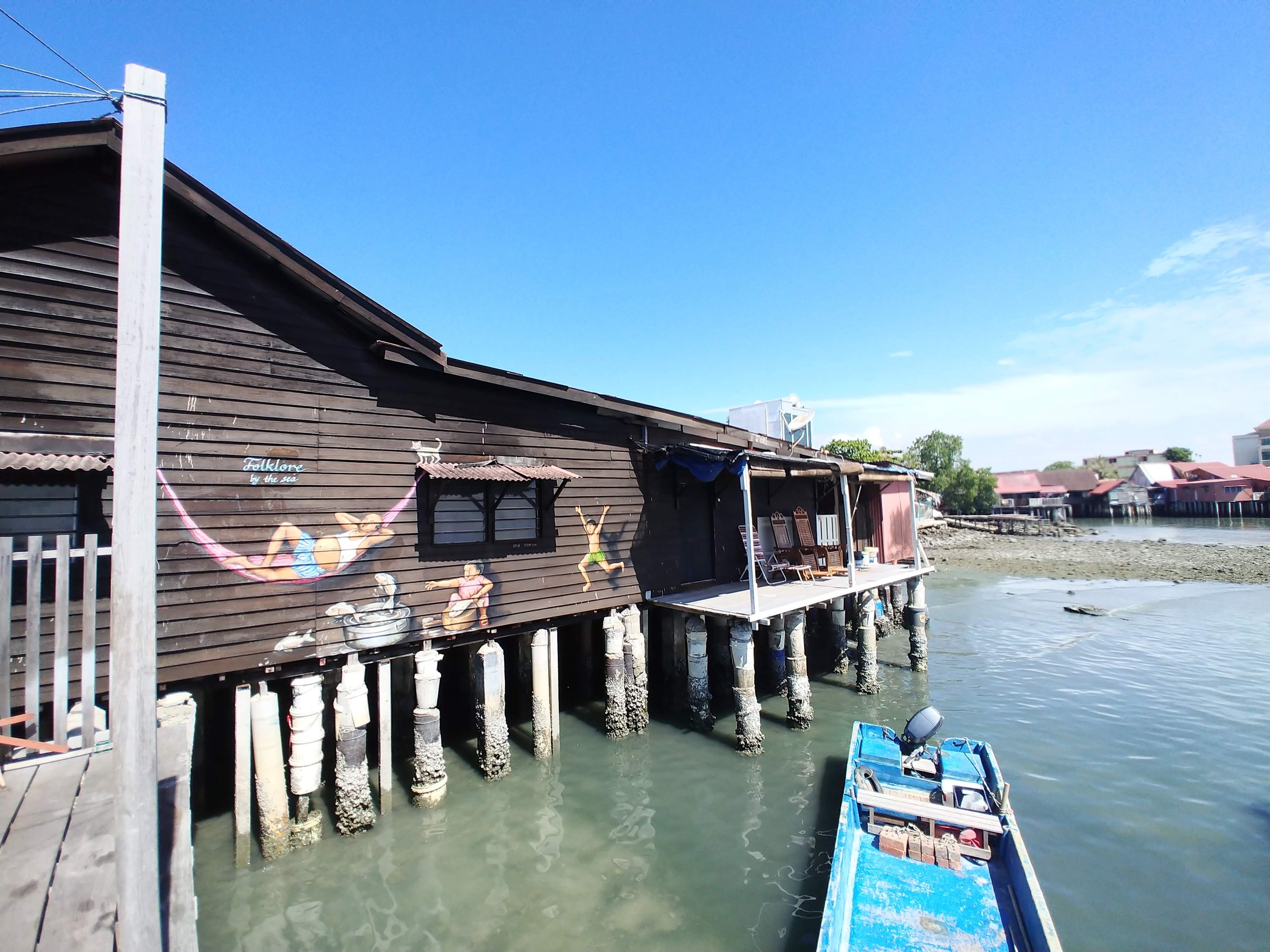 海の上に杭で建つ水上住宅と小舟