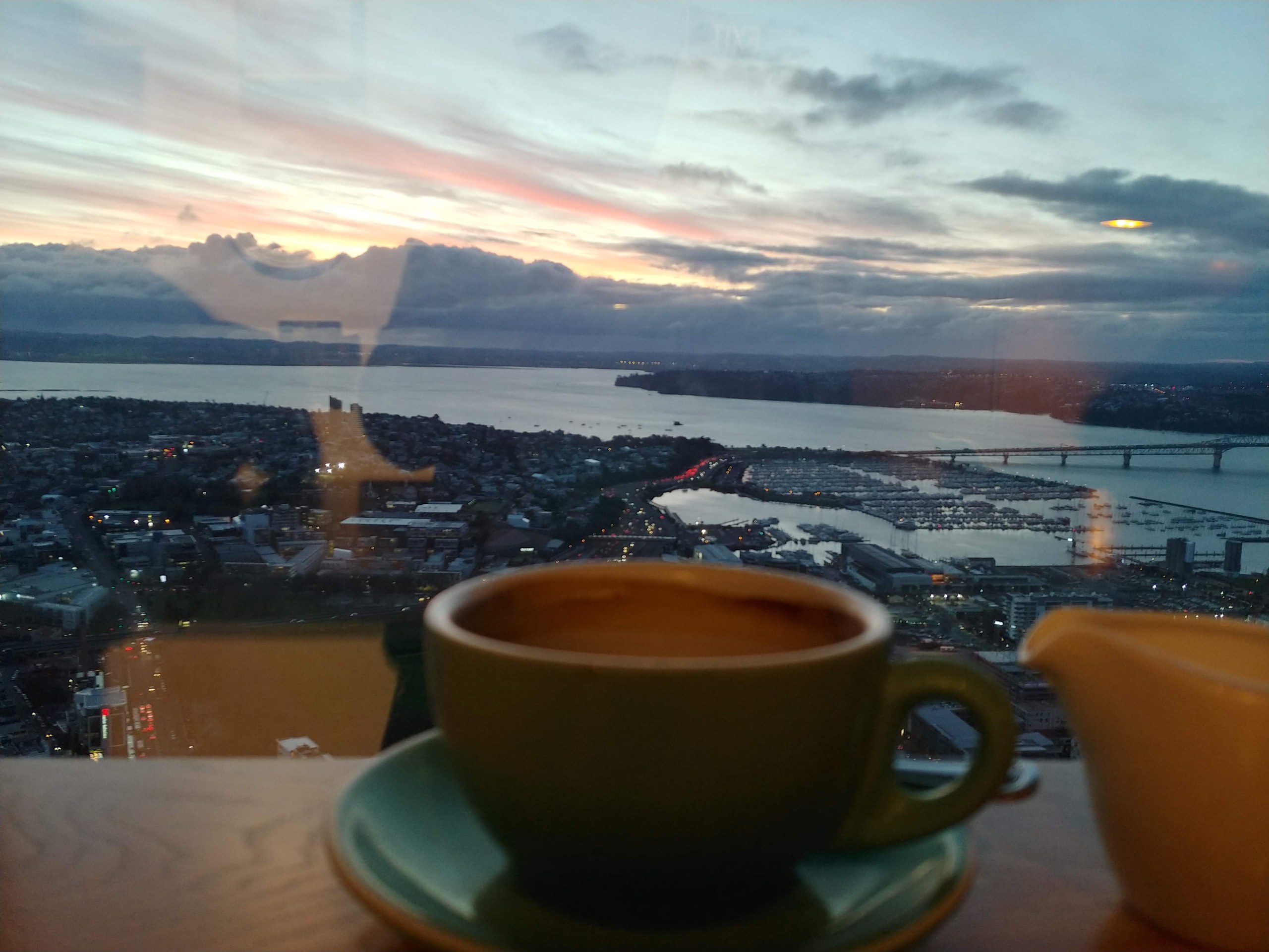カフェのコーヒーとオークランドの夕景
