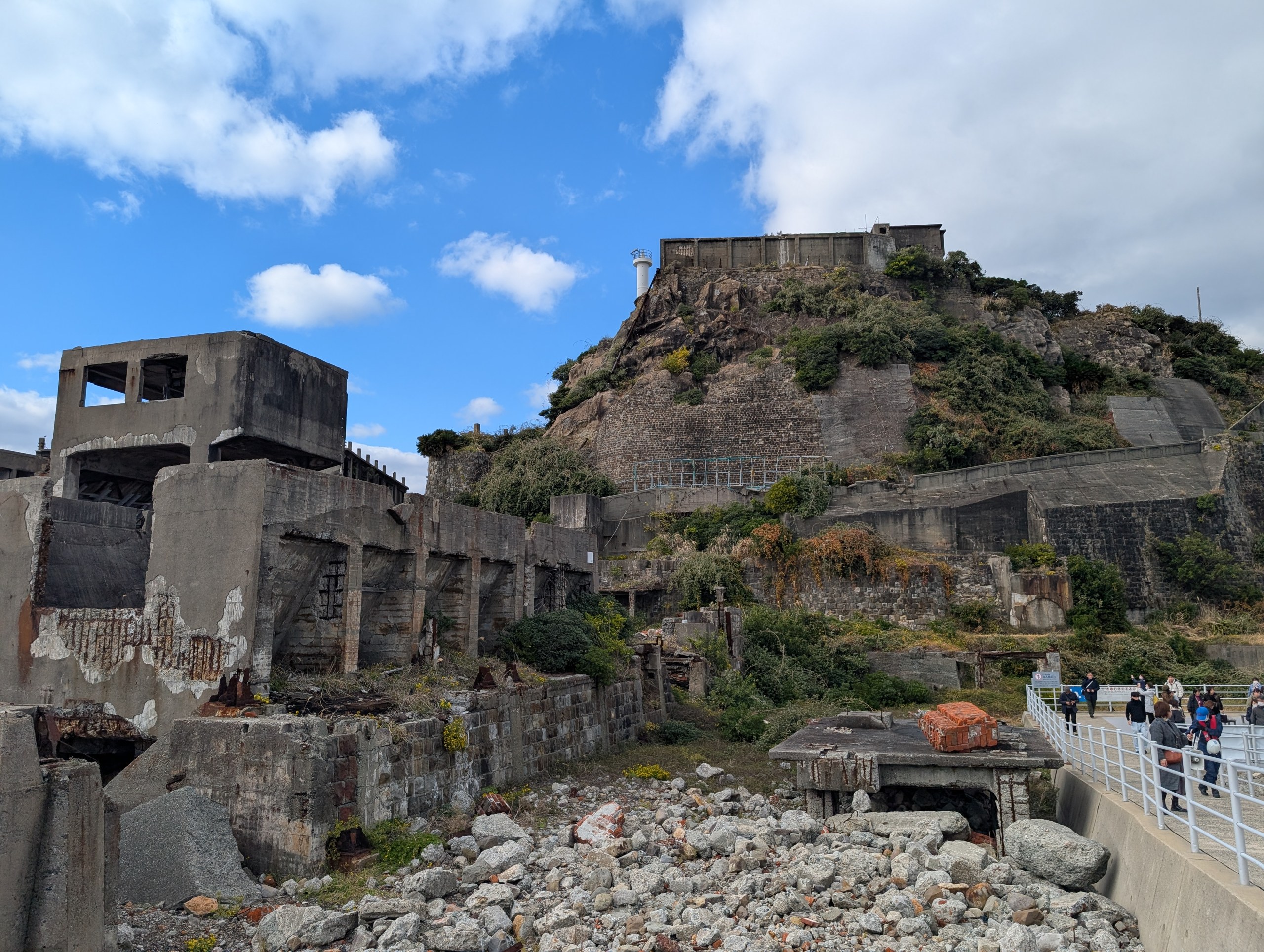 がれきの向こうに見える、島の建物と見学通路