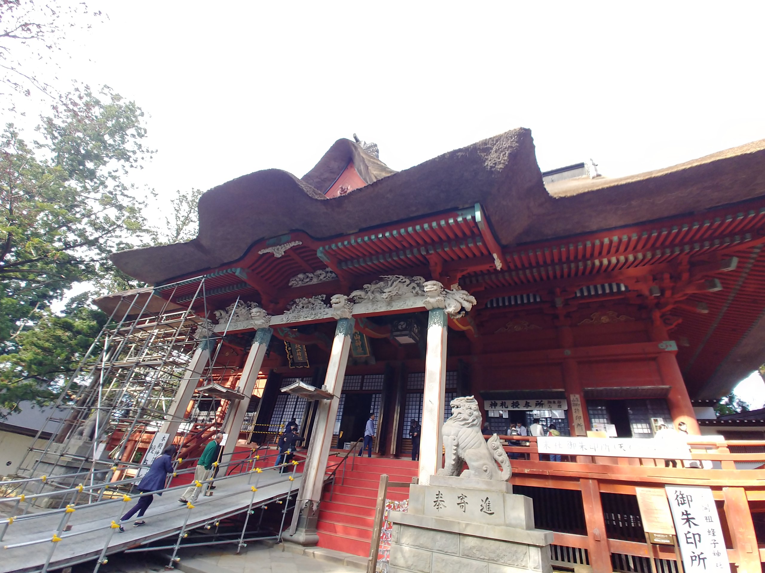 茅葺き屋根の三神合祭殿。一部に足場が組まれている