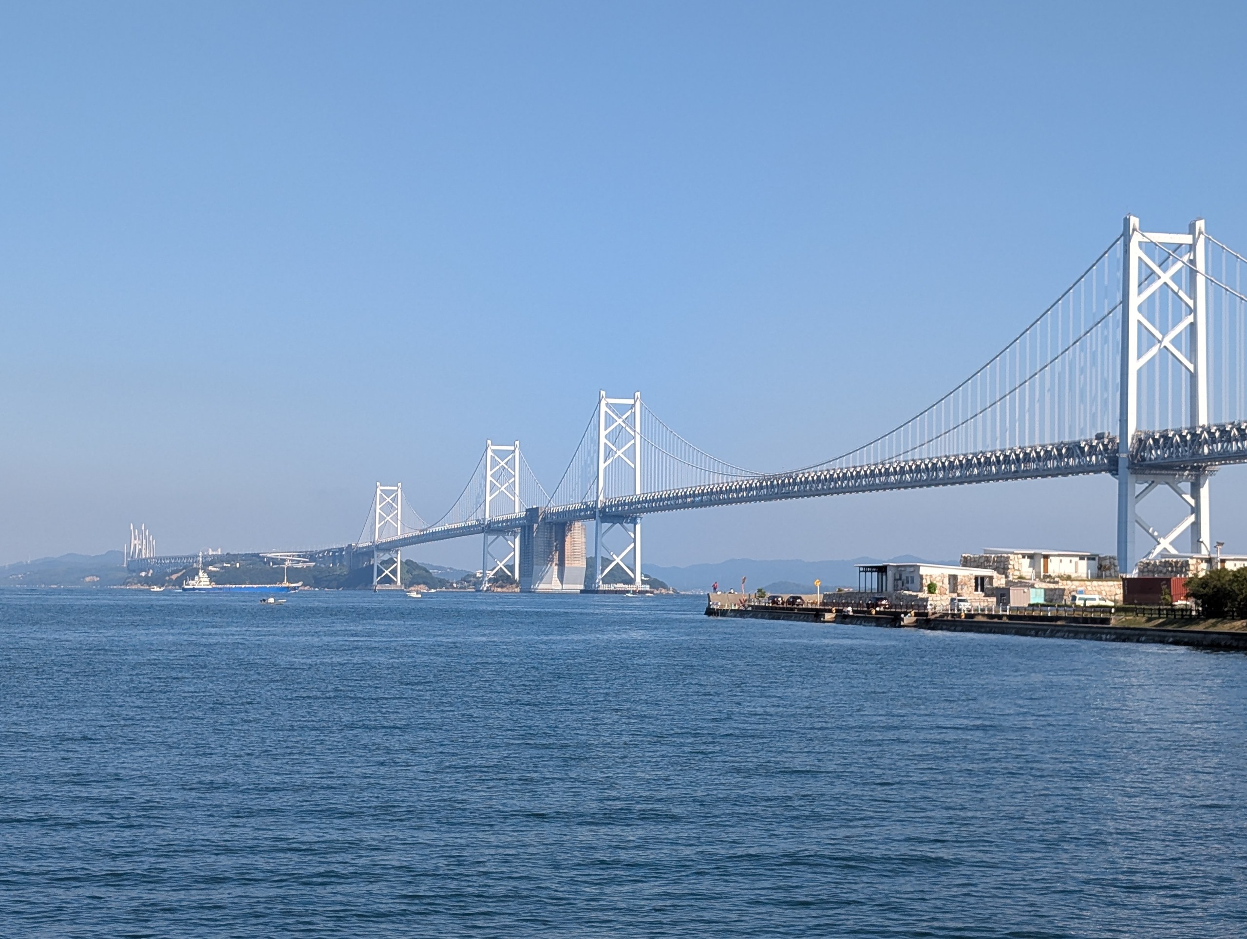 海辺から見た、島々をつないで延びる瀬戸大橋