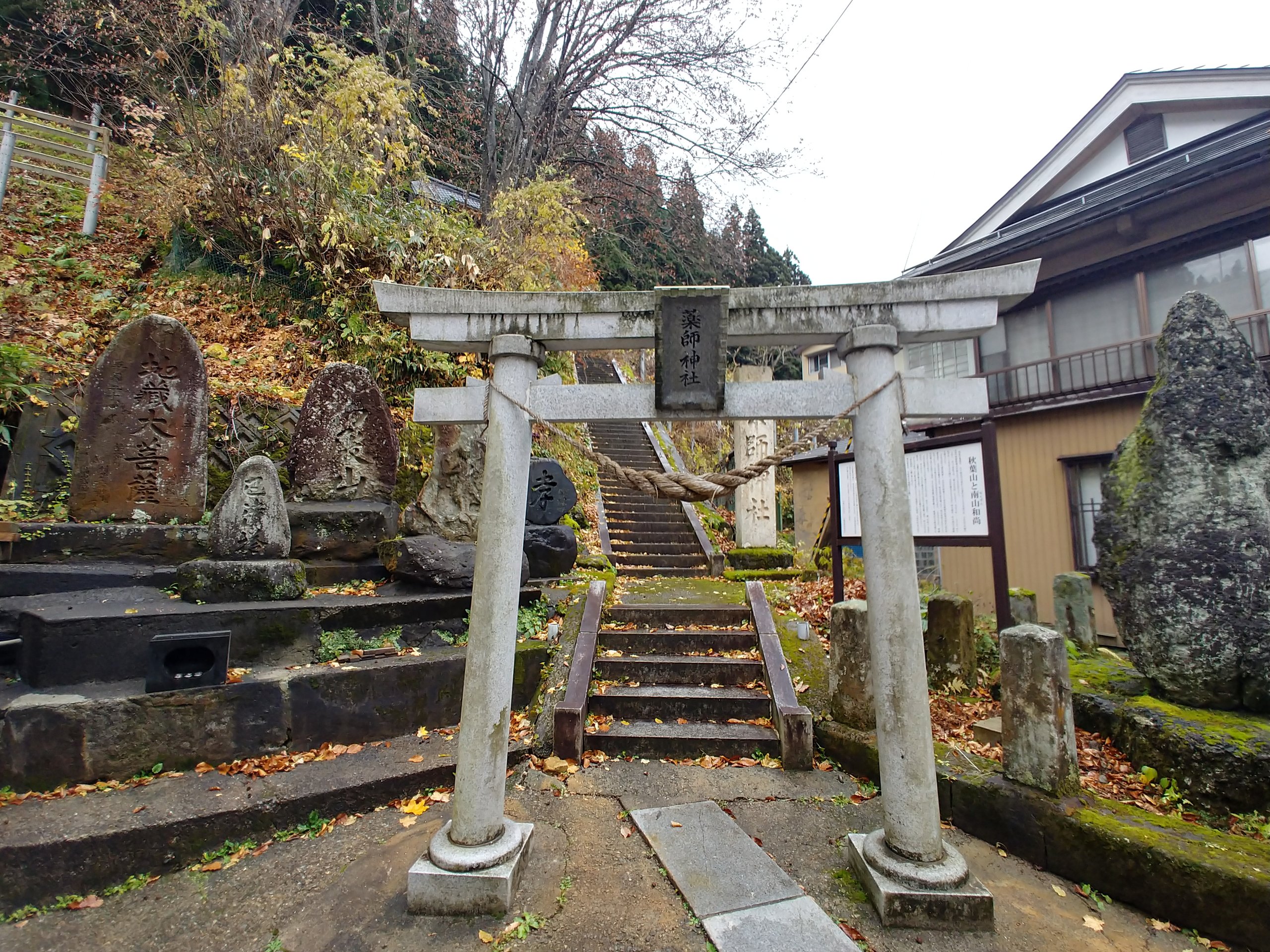 石段の上に鳥居と碑が並ぶ肘折温泉の薬師神社