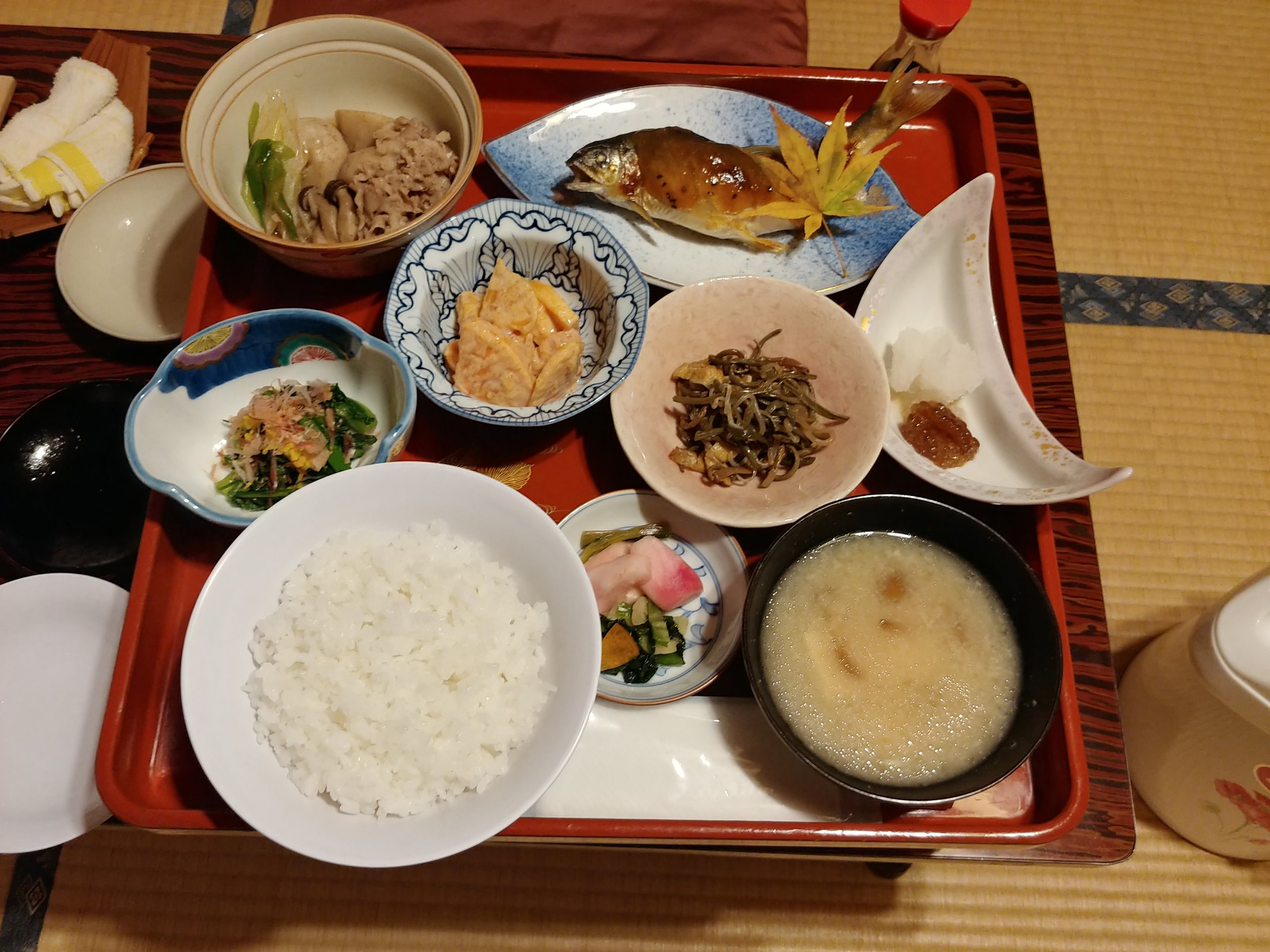 西本屋旅館の夕食。川魚の焼き物と小鉢が並ぶお膳