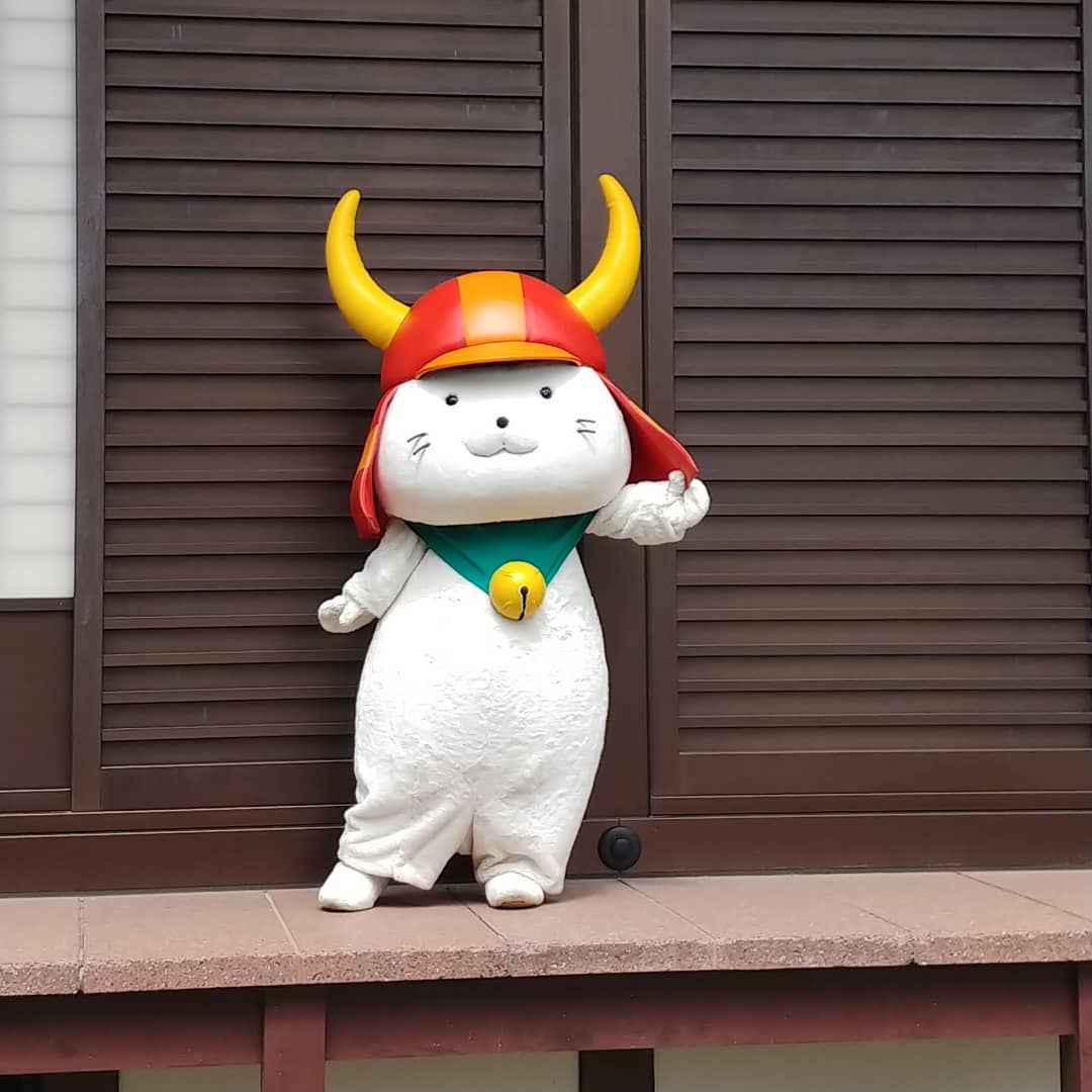 彦根城の建物の前に立つ、ひこにゃん
