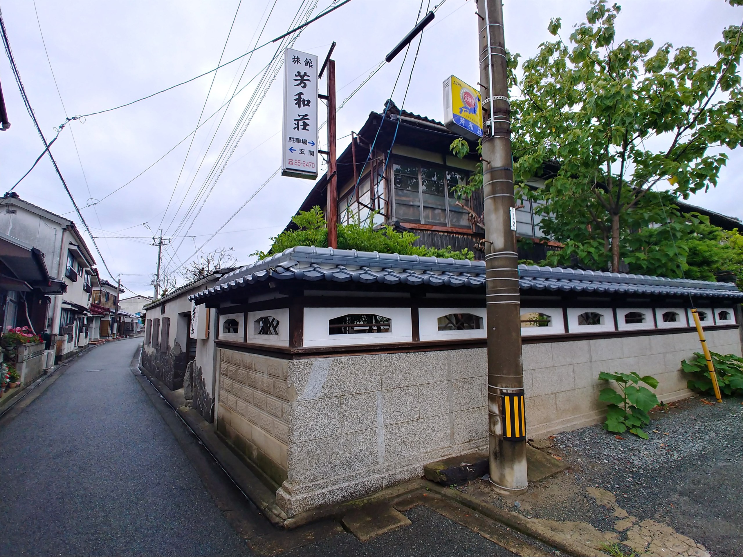 路地に立つ芳和荘の看板