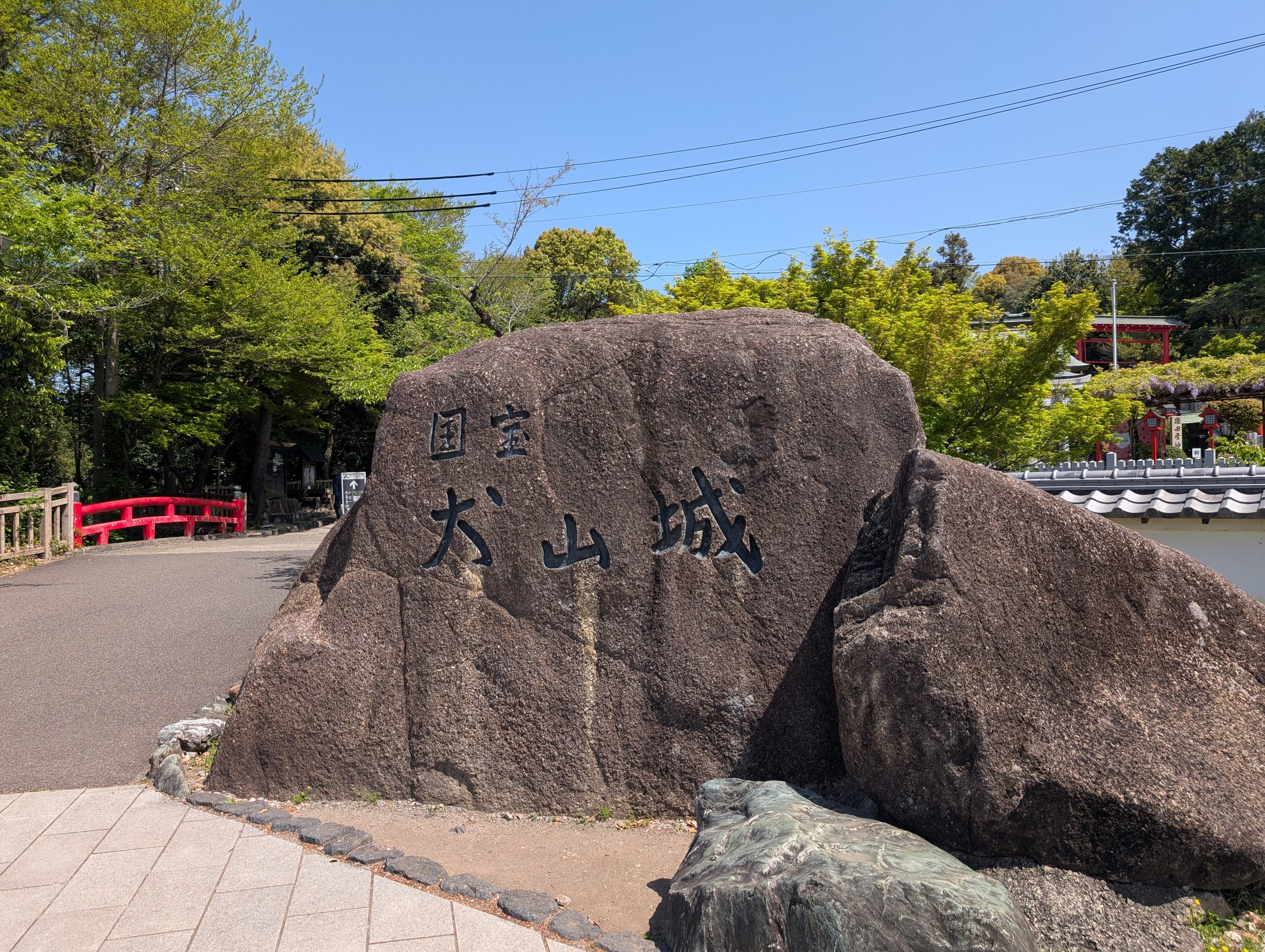 「国宝 犬山城」と刻まれた大きな石と、奥の赤い橋