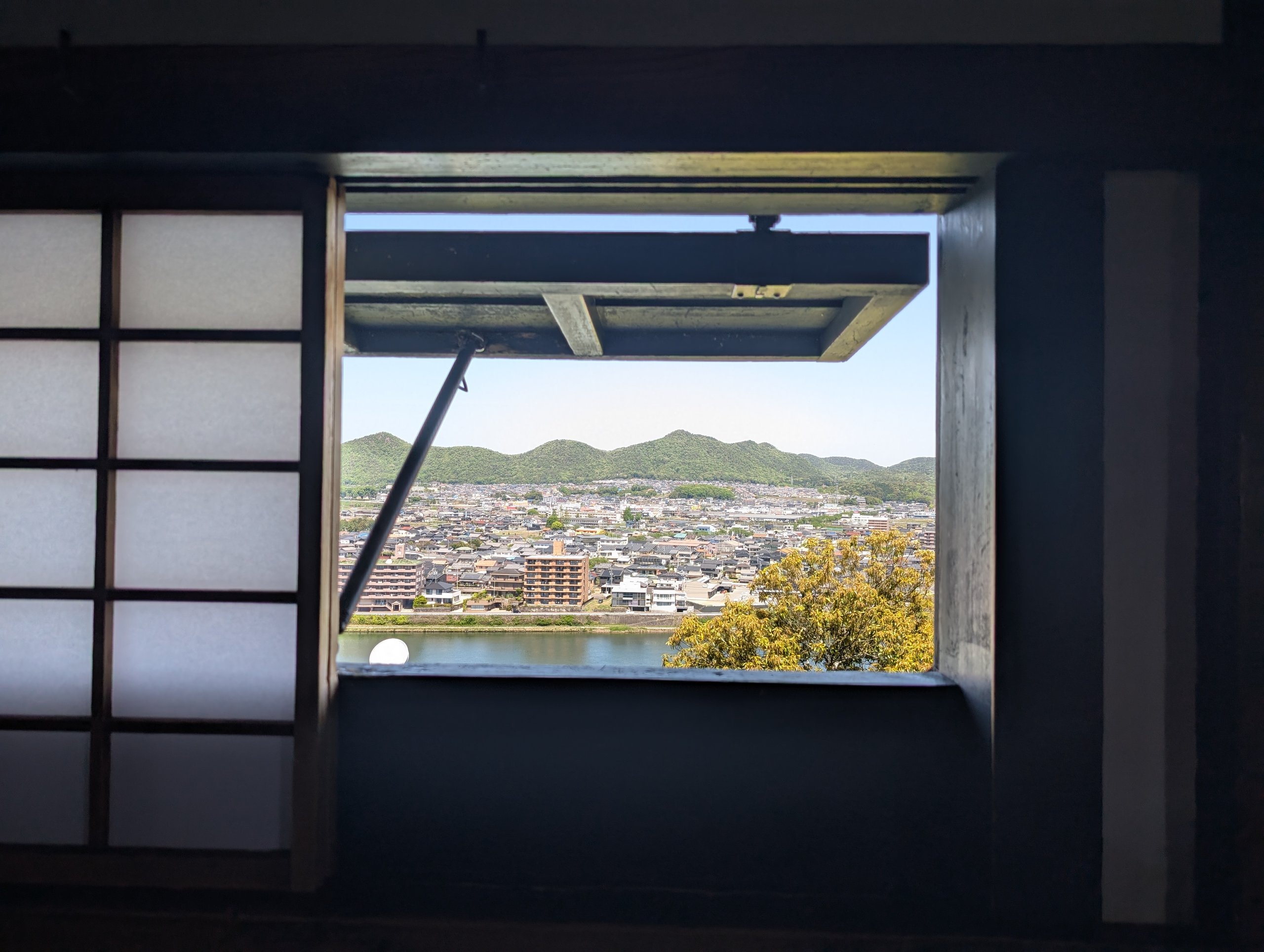 暗い天守の中から見た、窓の外の町と山