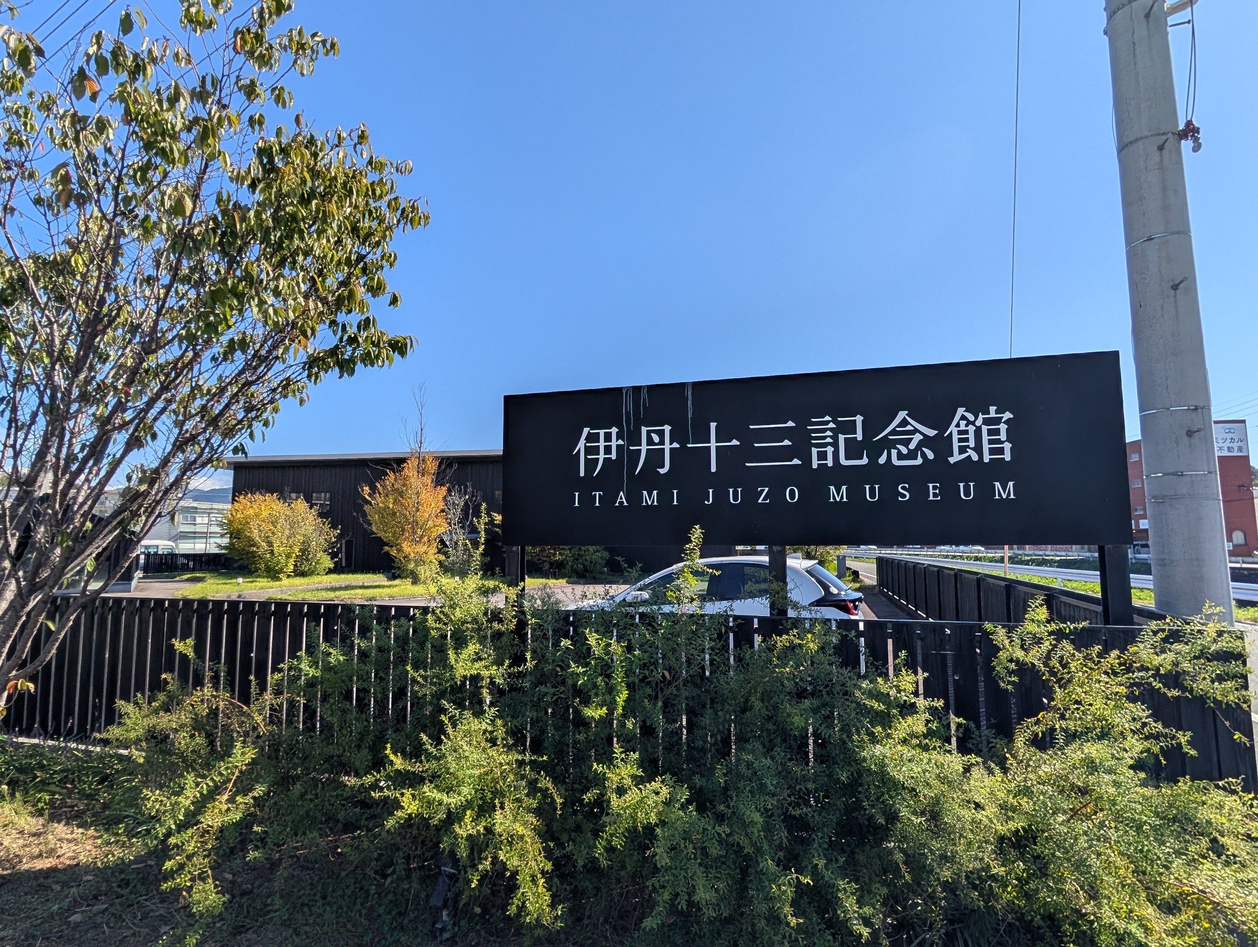 「伊丹十三記念館 ITAMI JUZO MUSEUM」の看板と、黒い建物