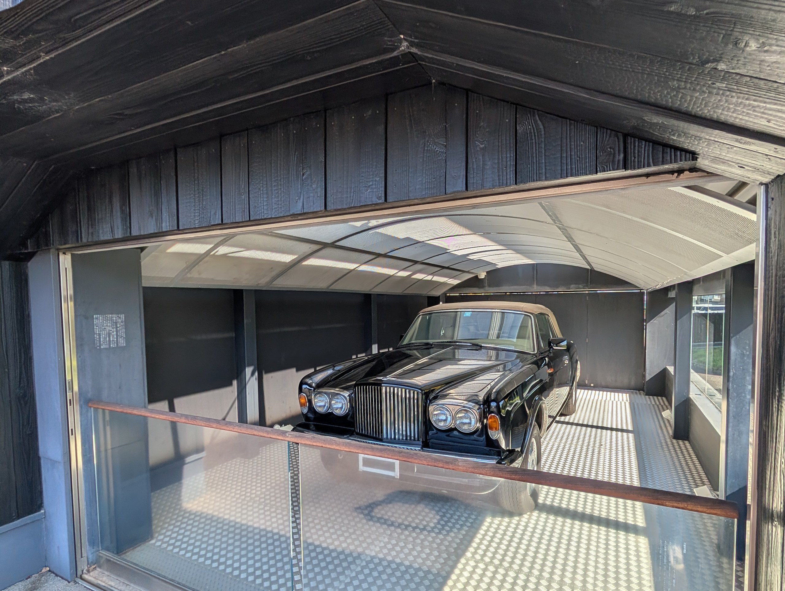 車庫のような展示室に置かれた、黒い大きな車