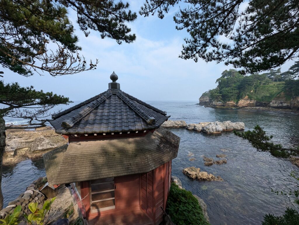 岩の上に建つ六角堂と、その向こうの海