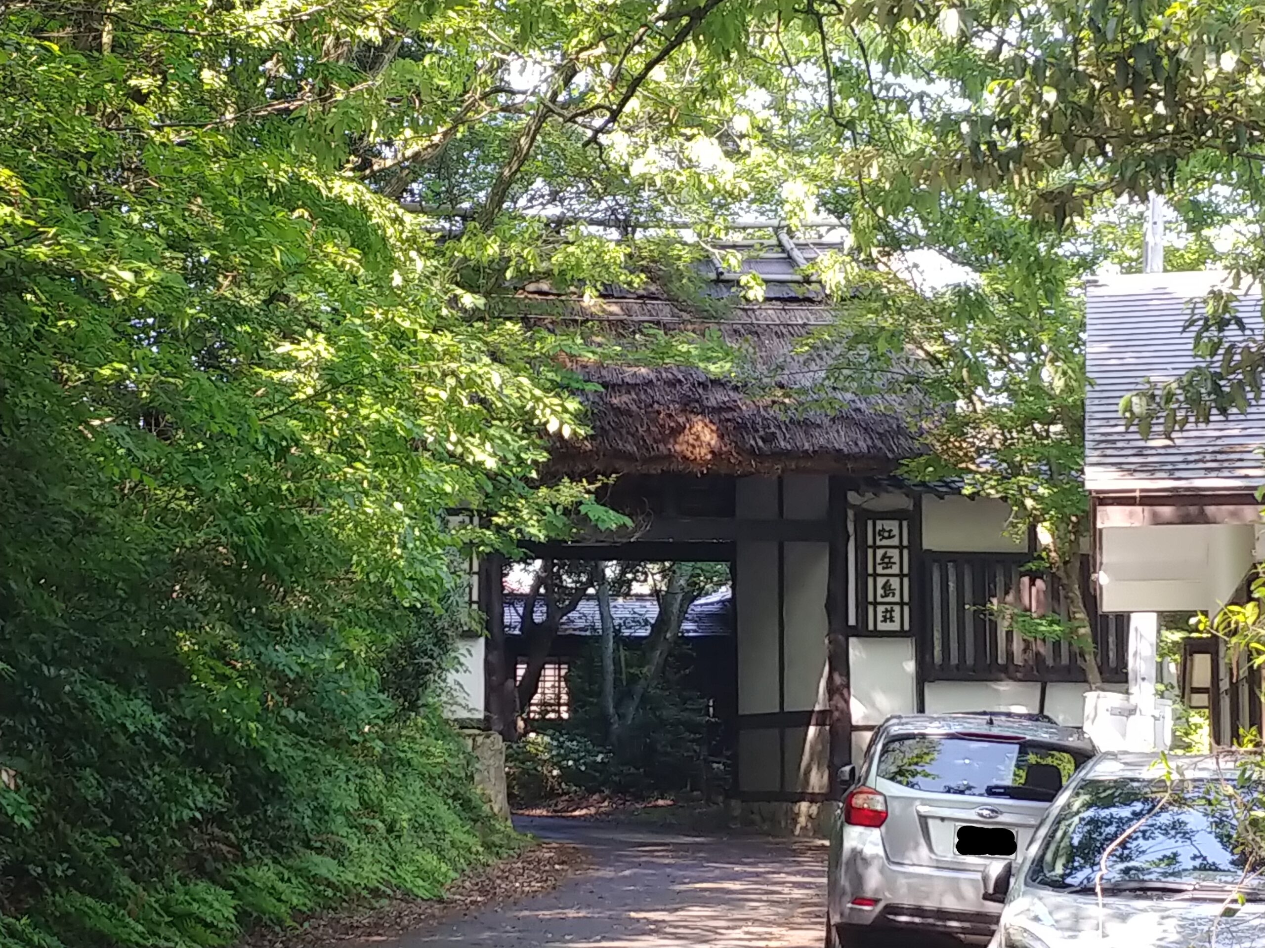 木々に囲まれた虹岳島荘の入口