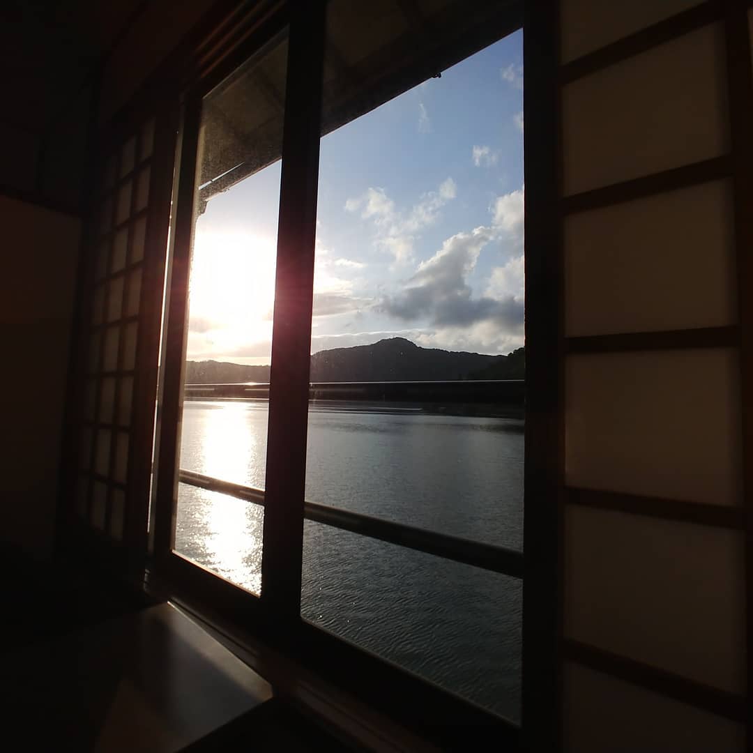 障子の窓から見える、夕方の湖と山
