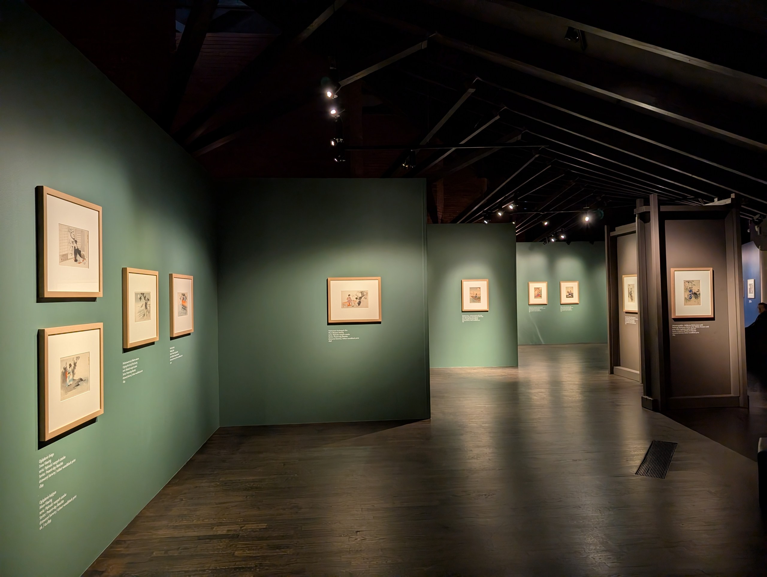 緑の壁に版画が並ぶ、展示室