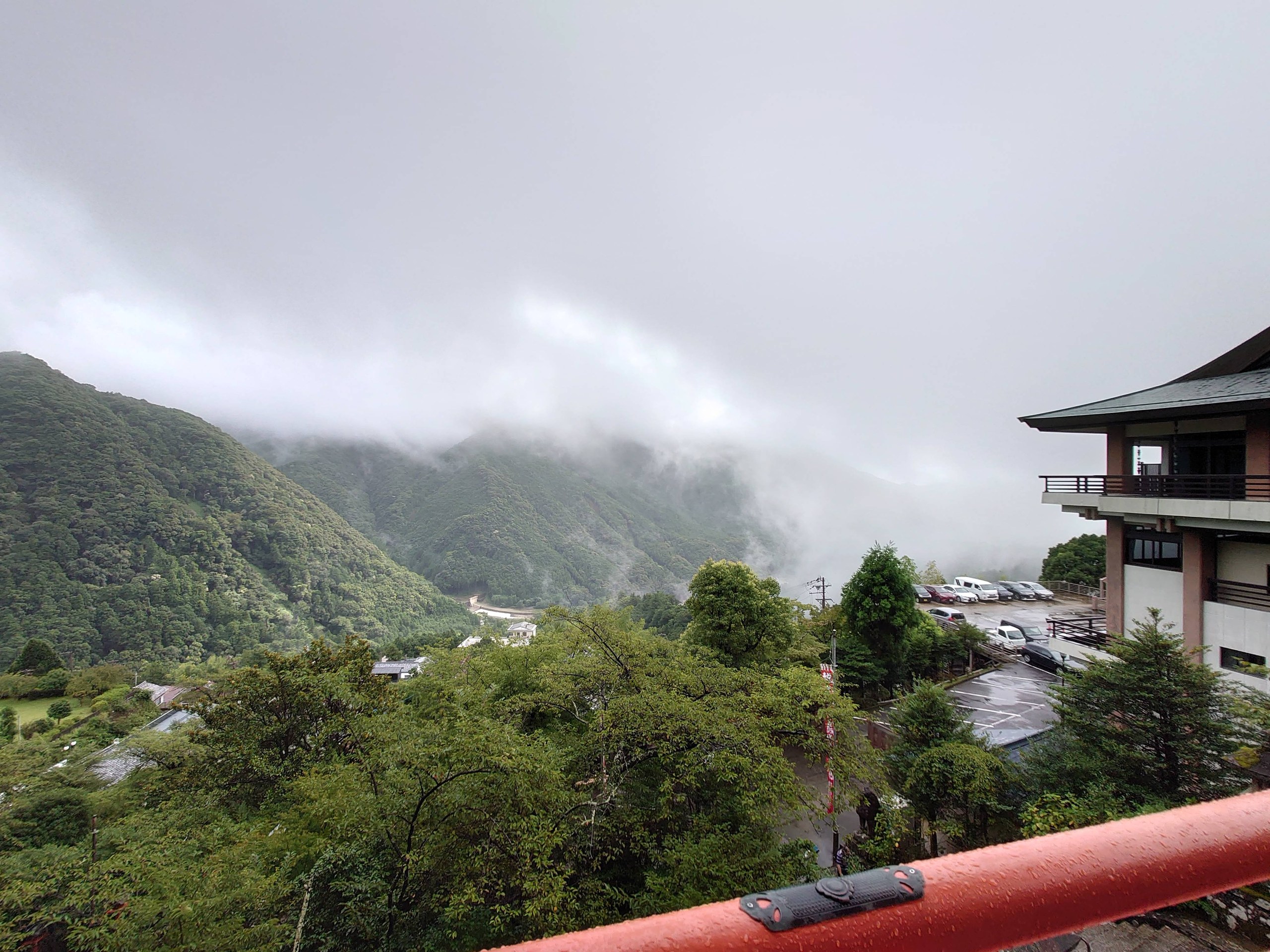 境内から見下ろした、雲がかかる山あいの景色