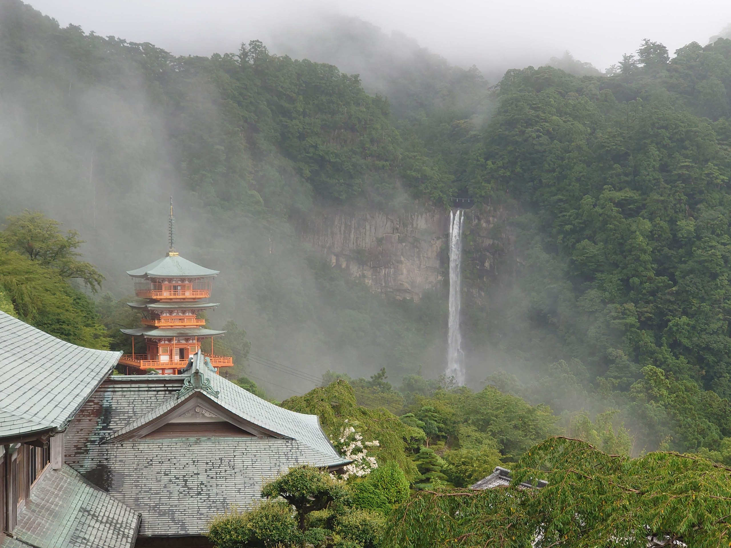 朱色の三重塔の向こうに落ちる那智の滝