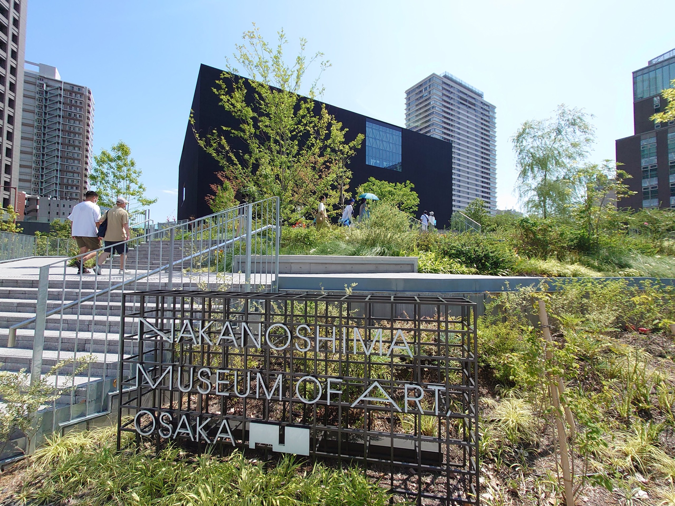 「NAKANOSHIMA MUSEUM OF ART, OSAKA」の看板と、植え込みの先の建物