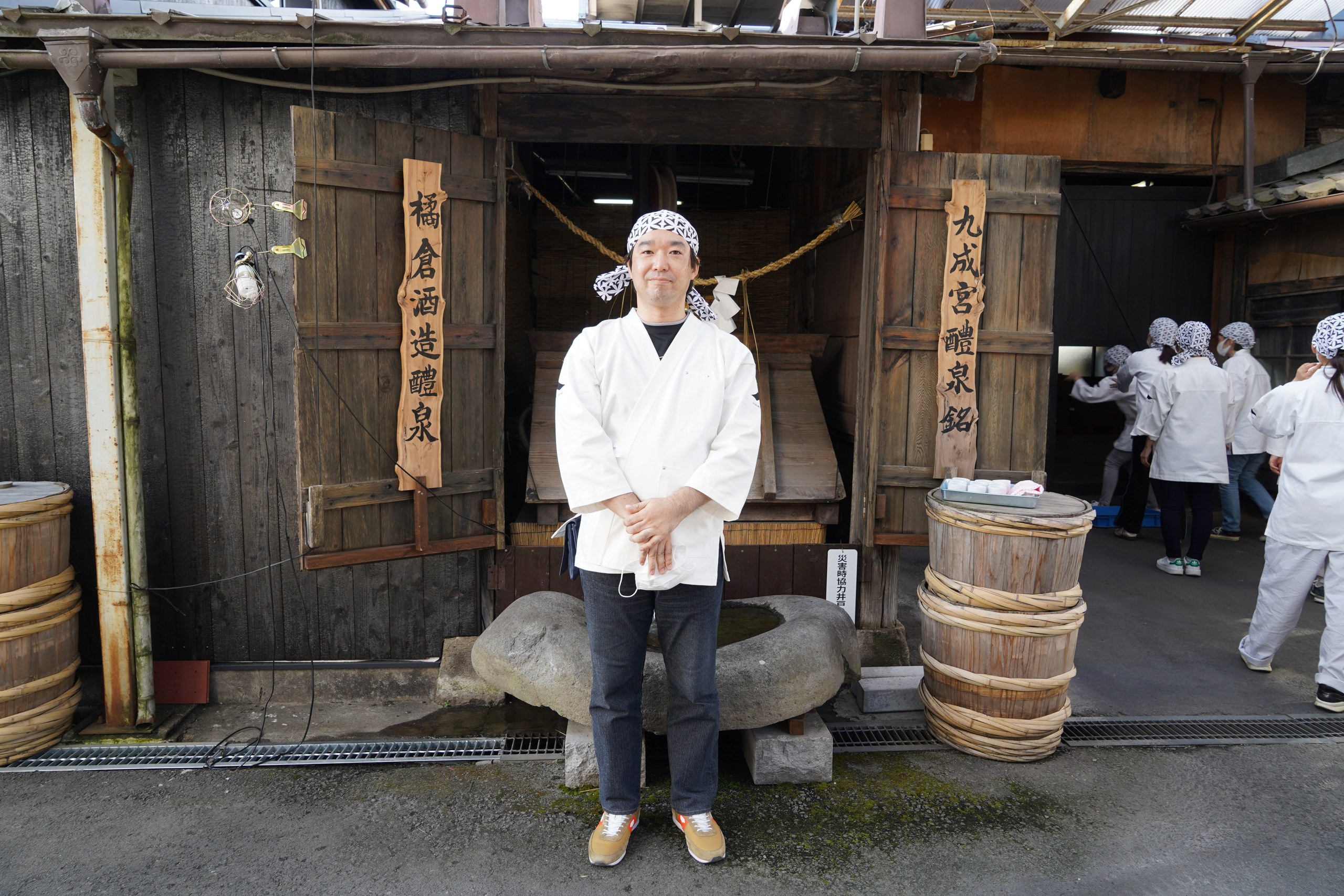 蔵の前に立つ作業着姿の私