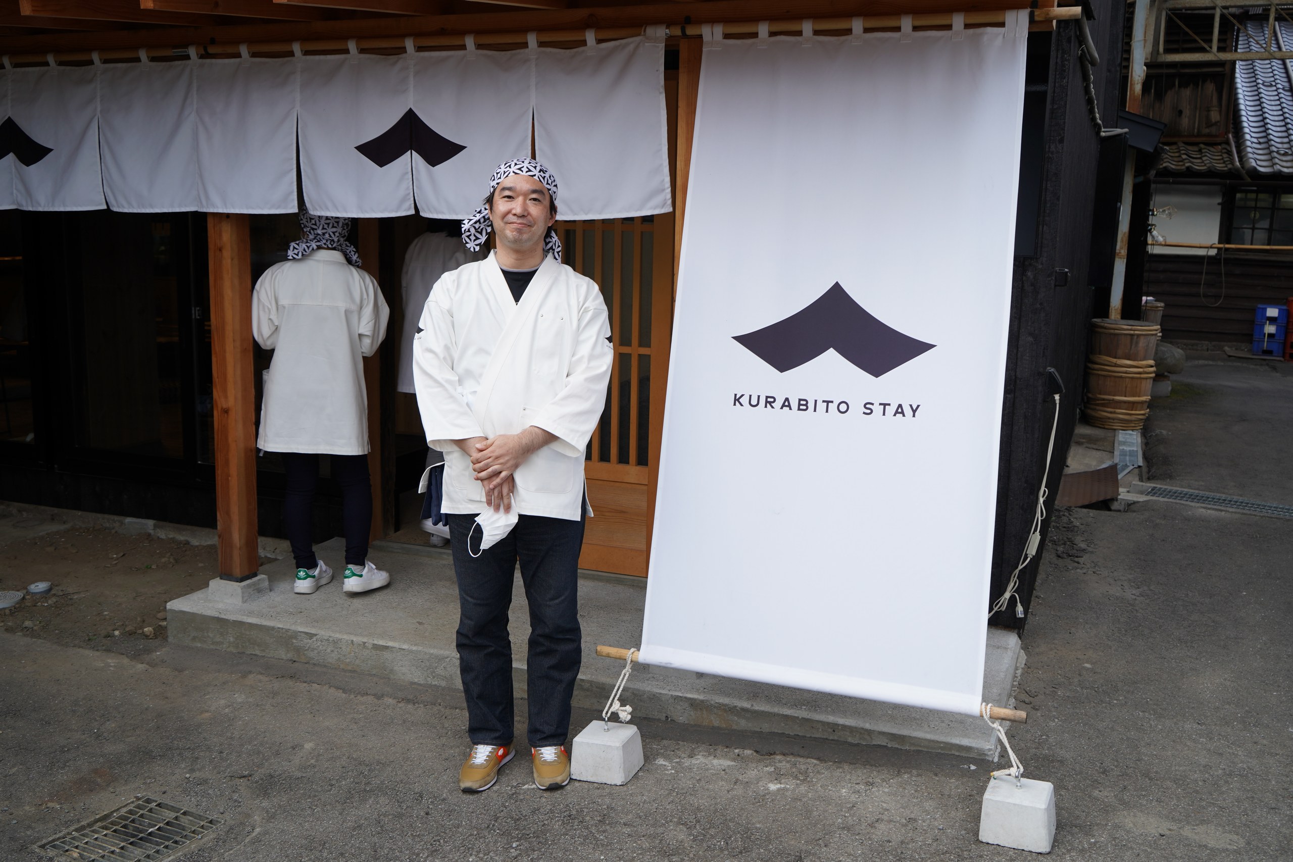 KURABITO STAYの旗の前で