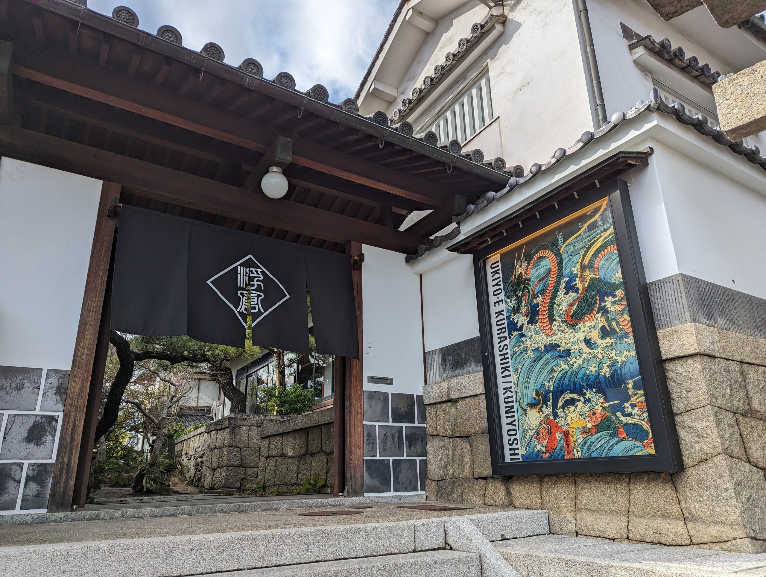 浮世絵の大きな看板が掛かる、国芳館の入口