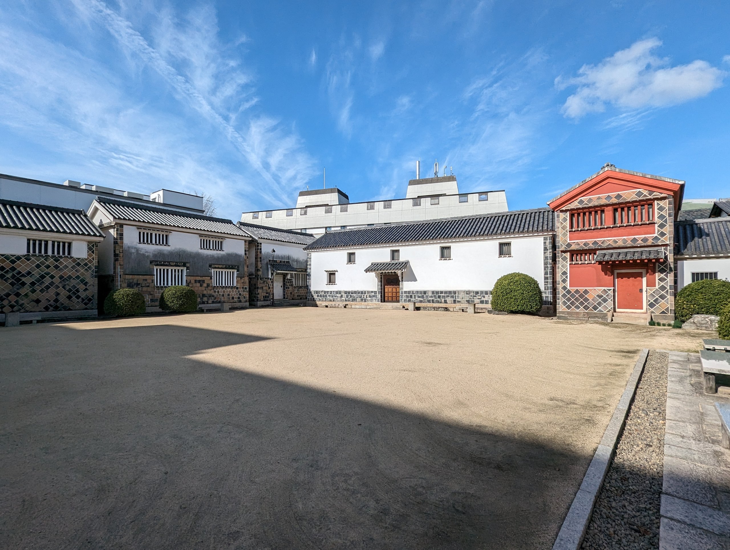 白壁と赤い外壁の建物が並ぶ、大原美術館の中庭