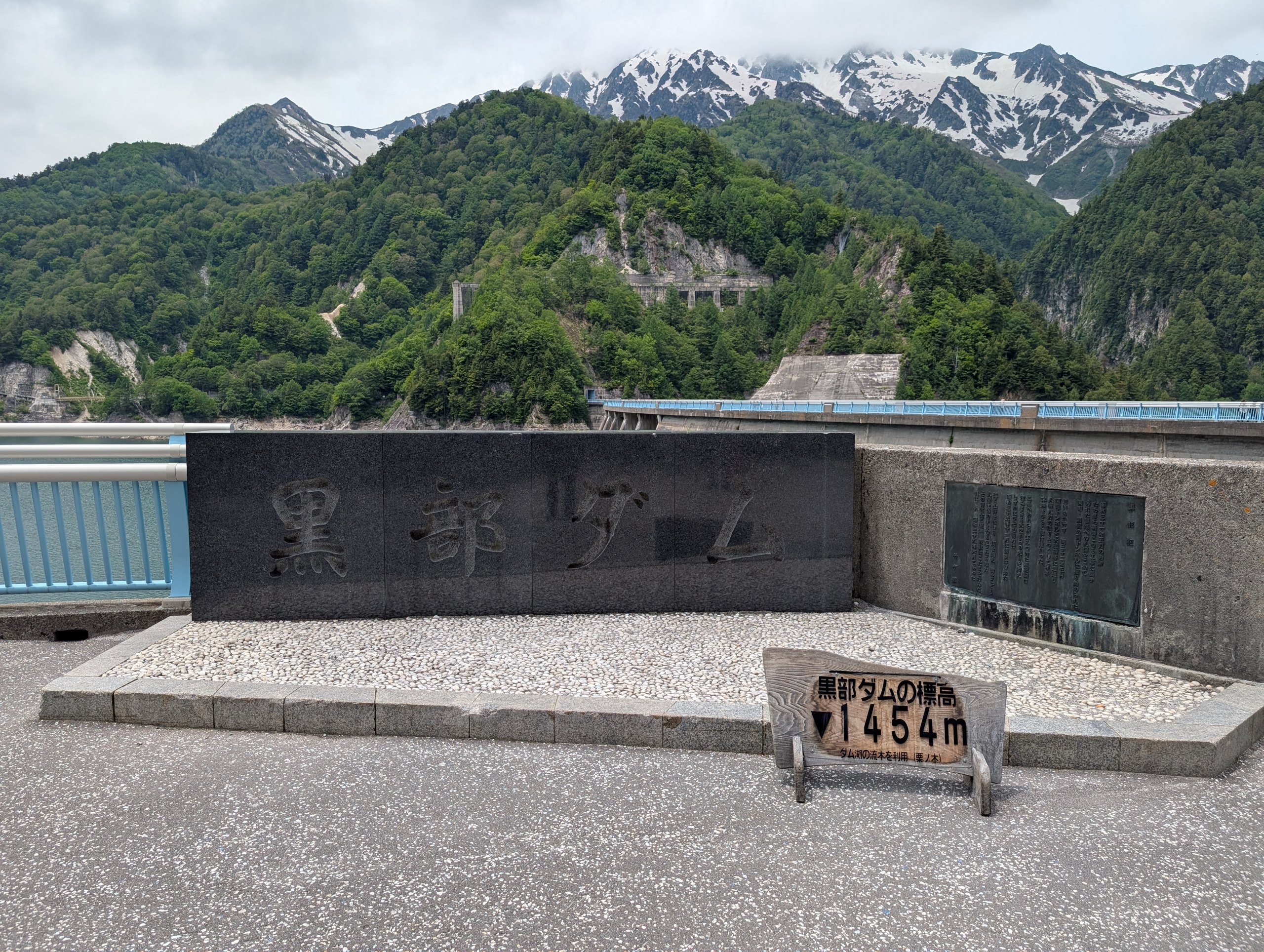 「黒部ダム」の石碑と、「黒部ダムの標高 ▼1454m」の看板