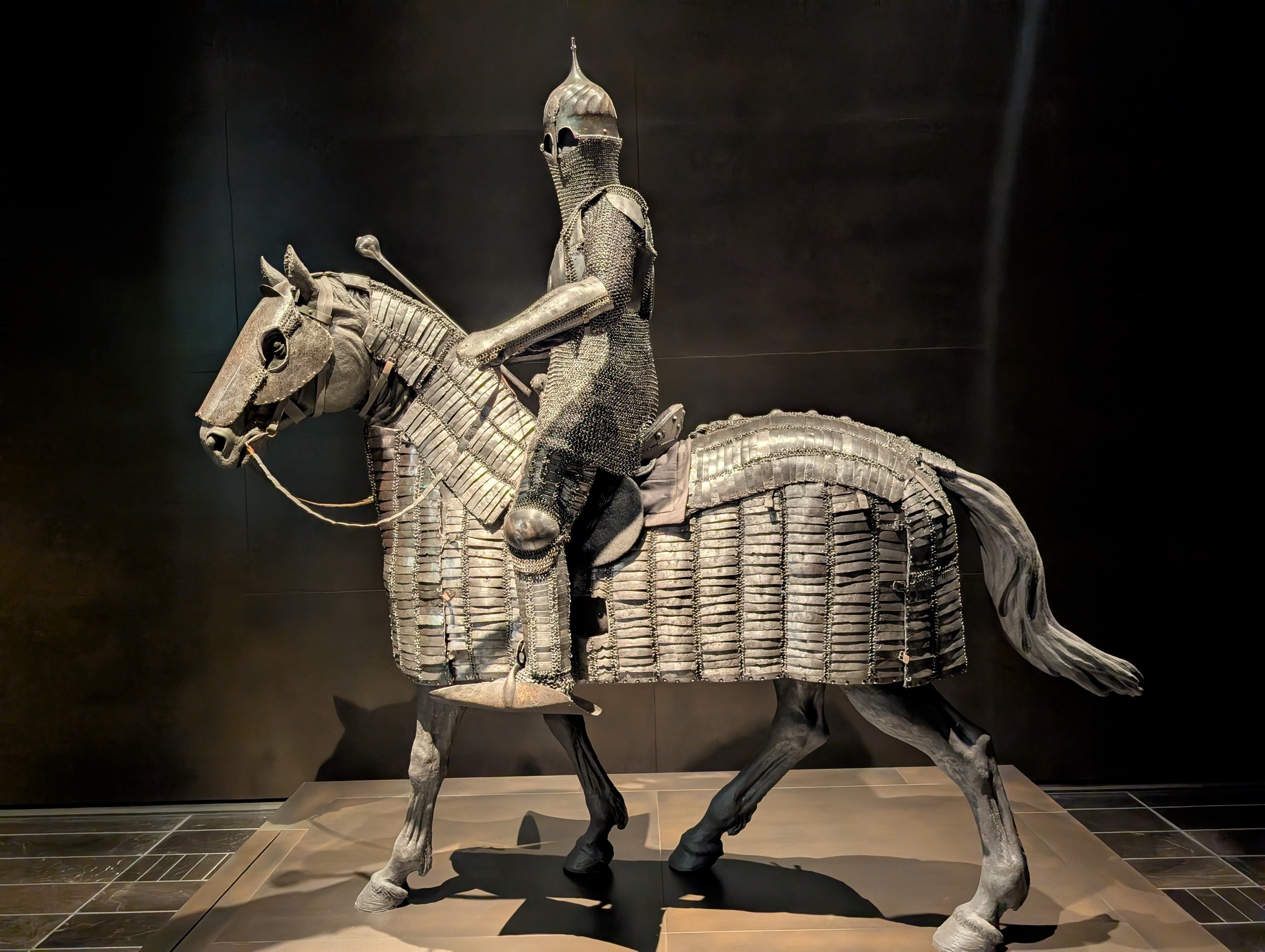 よろいを着た人物と、うろこのようなよろいをまとった馬の像