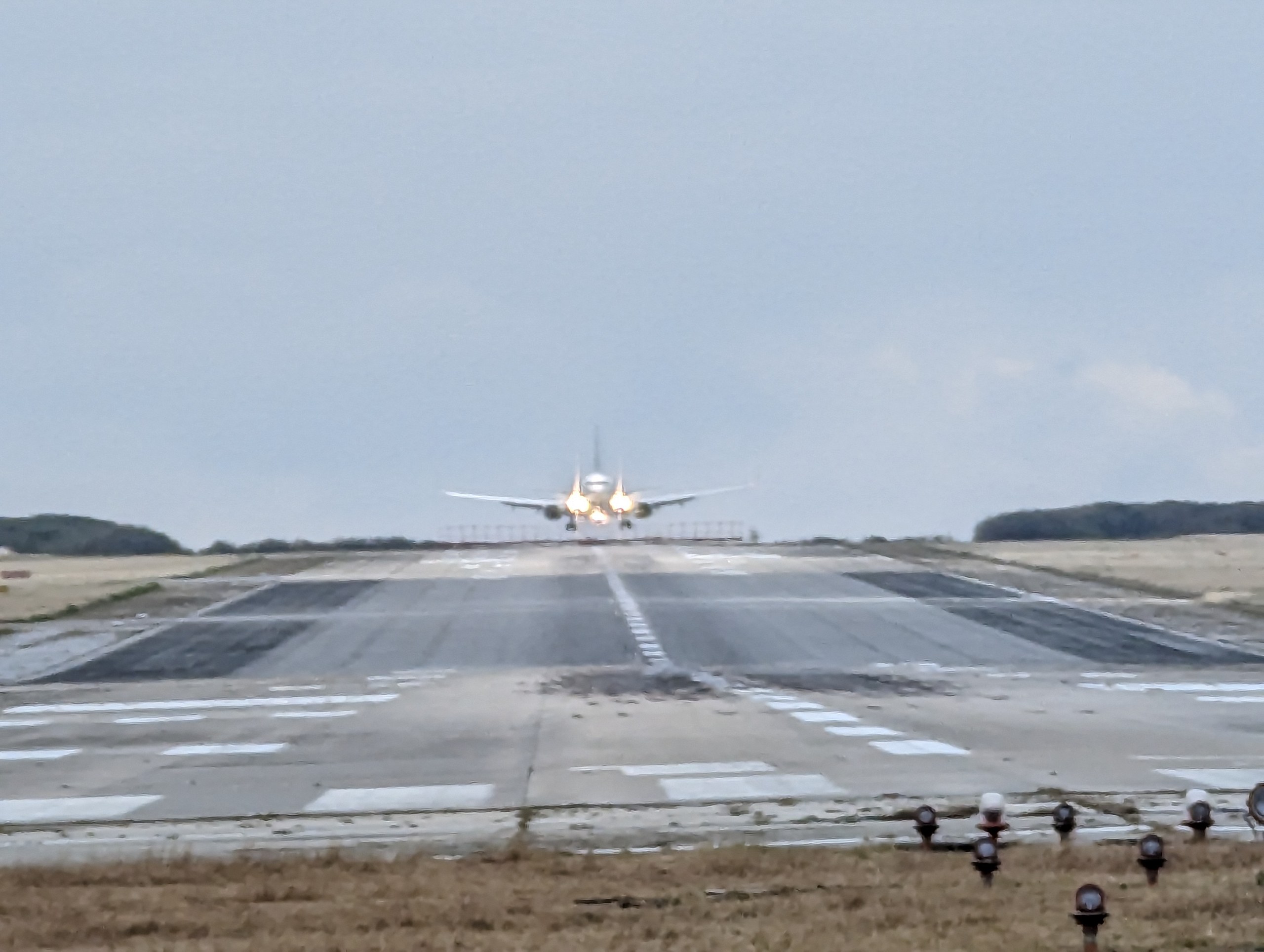 滑走路を進んでくる旅客機を正面から見た様子